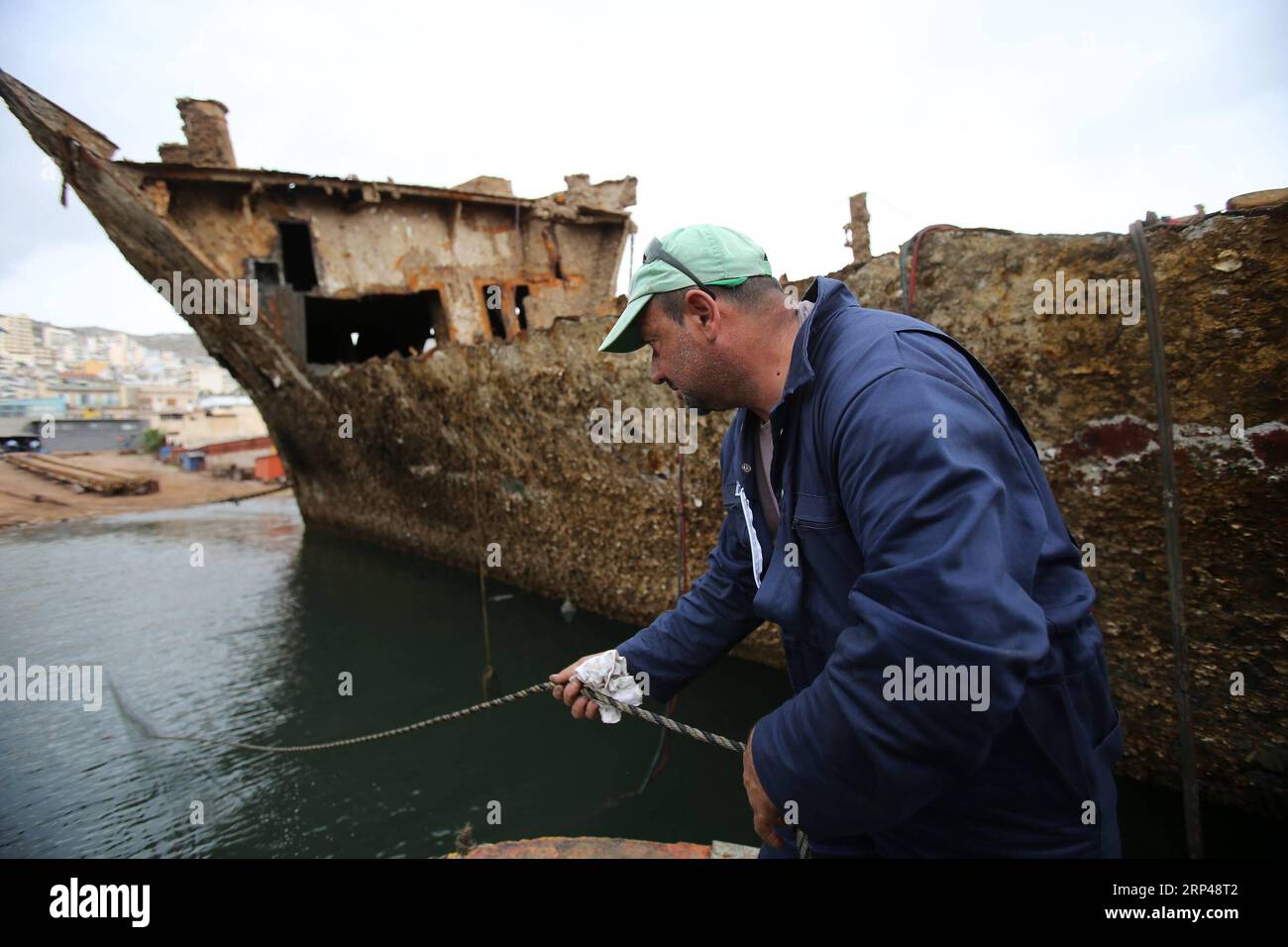 (181031) -- PERAMA, le 31 octobre 2018 -- un ouvrier enlève les débris du naufrage de l'île de Corfou dans la zone de réparation de Perama, en Grèce, le 30 octobre 2018. Trente-deux ans après son naufrage sur le quai II de la zone de réparation navale de Perama, l'île de Corfou a été récupérée cet automne. La levée et le remorquage de l'épave du ferry appartenant à la Grèce est la première étape d'un projet plus vaste lancé par les autorités grecques pour nettoyer les eaux du golfe Saronique de dizaines de tels naufrages, ont déclaré mardi les responsables ici. GRÈCE-NAUFRAGE-RÉCUPÉRATION MariosxLolos PUBLICATIONxNOTxINxCHN Banque D'Images