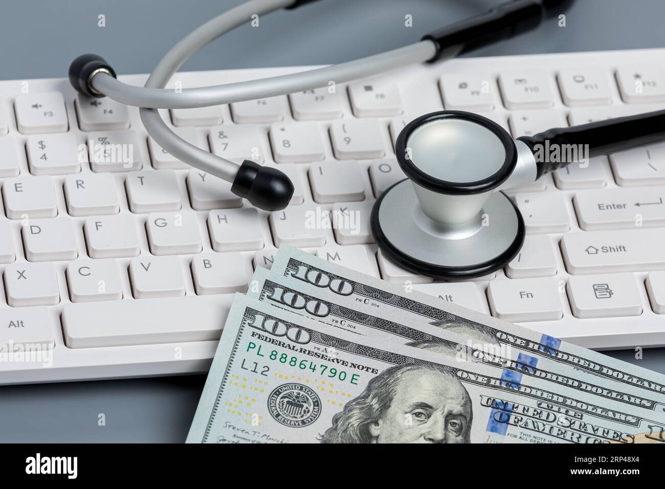 Stéthoscope, clavier d'ordinateur, et argent comptant. Dossiers médicaux, sécurité des données, ransomware et concept de cyberattaque. Banque D'Images