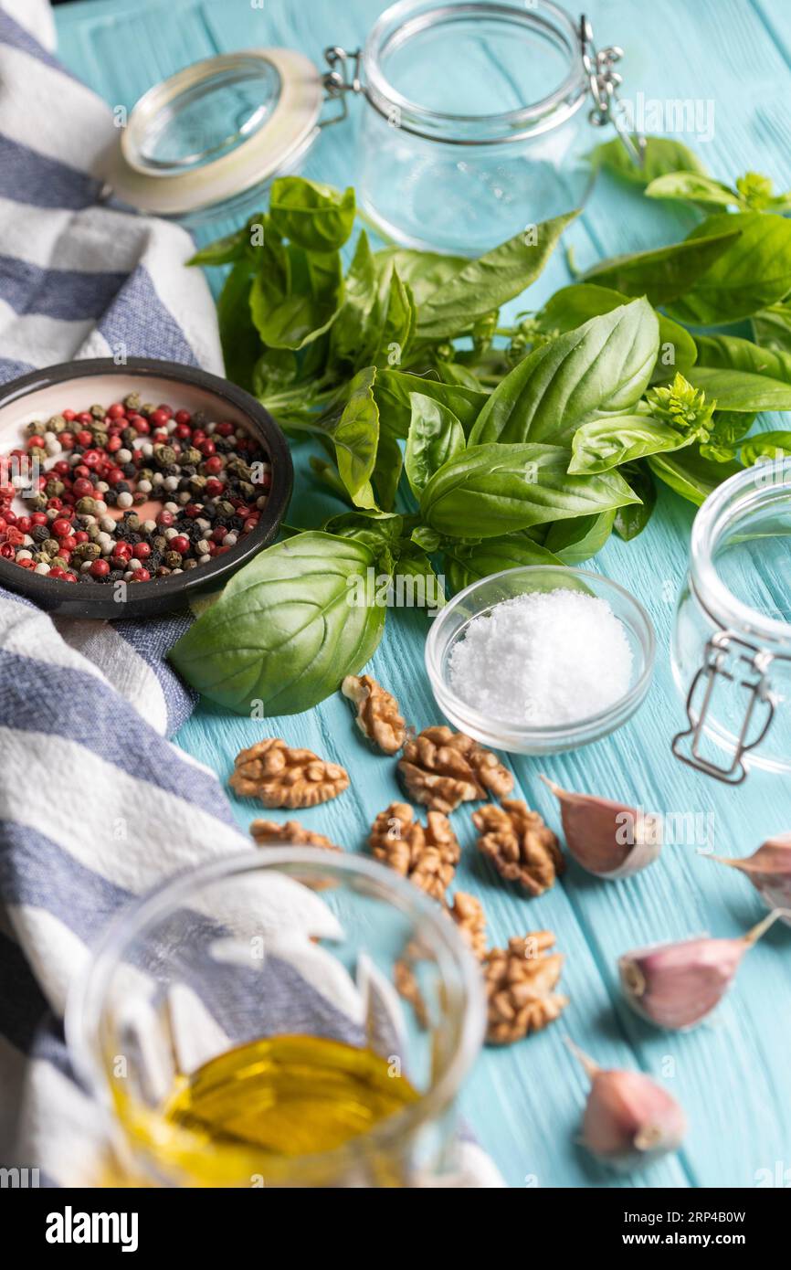 ingrédients et pots pour sauce pesto - basilic, ail, noix, sel, poivre, huile d'olive Banque D'Images