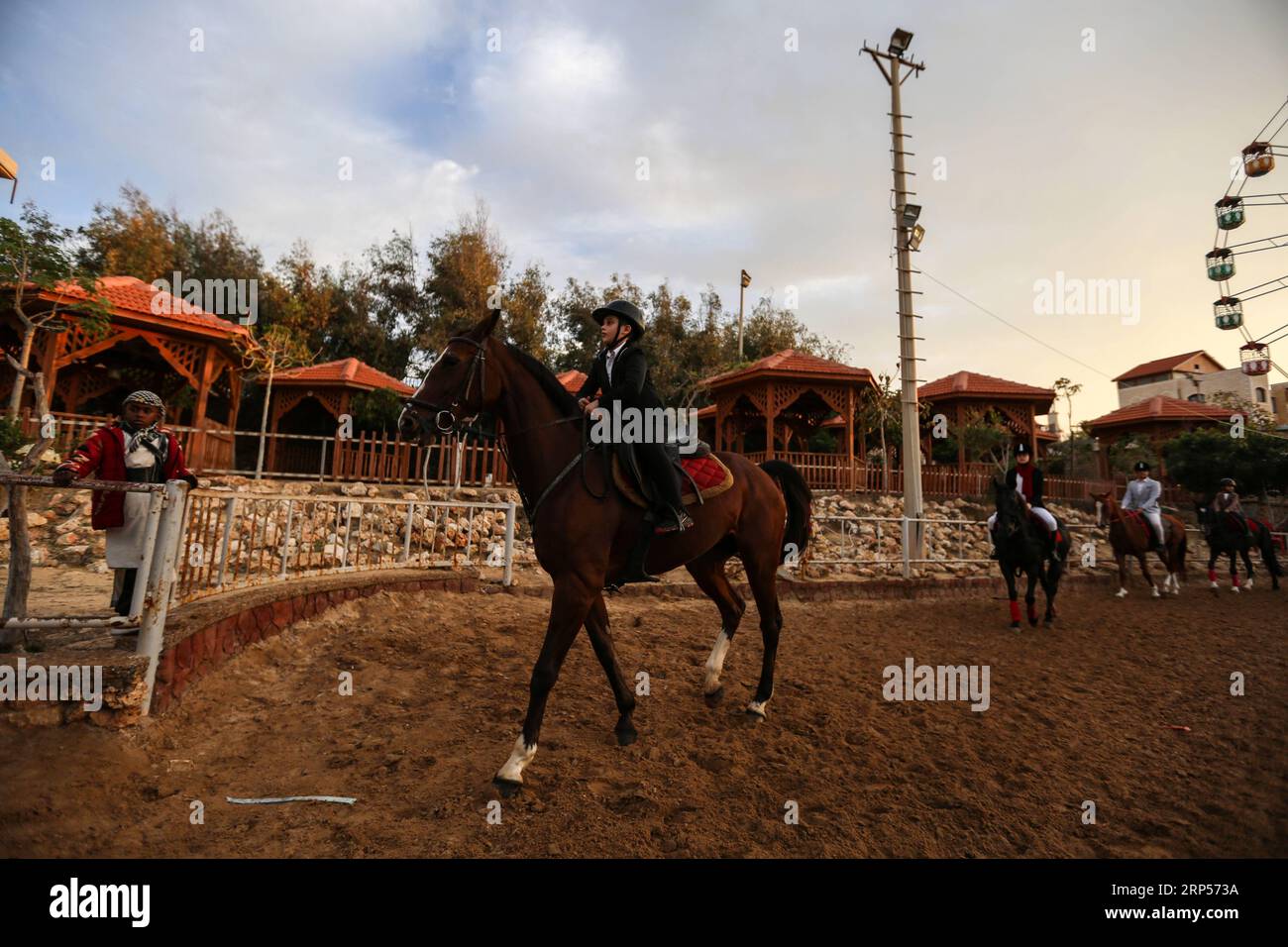 (181201) -- GAZA, 1 décembre 2018 -- des Palestiniens montent à cheval lors d'une compétition équestre dans la ville de Gaza, le 29 novembre 2018. La Fédération équestre palestinienne à Gaza a organisé jeudi soir une compétition locale pour franchir les barrières sous le titre Will and Hope, marquant la prochaine Journée internationale des personnes handicapées, qui tombe le 3 décembre de chaque année. Au total, 35 participants et leurs familles se sont joints à un rassemblement public de personnes handicapées dans un club équestre dans le nord de la ville de Gaza pour montrer leur soutien aux personnes handicapées. POUR ALLER AVEC la fonctionnalité : l'équitation se développe amon Banque D'Images