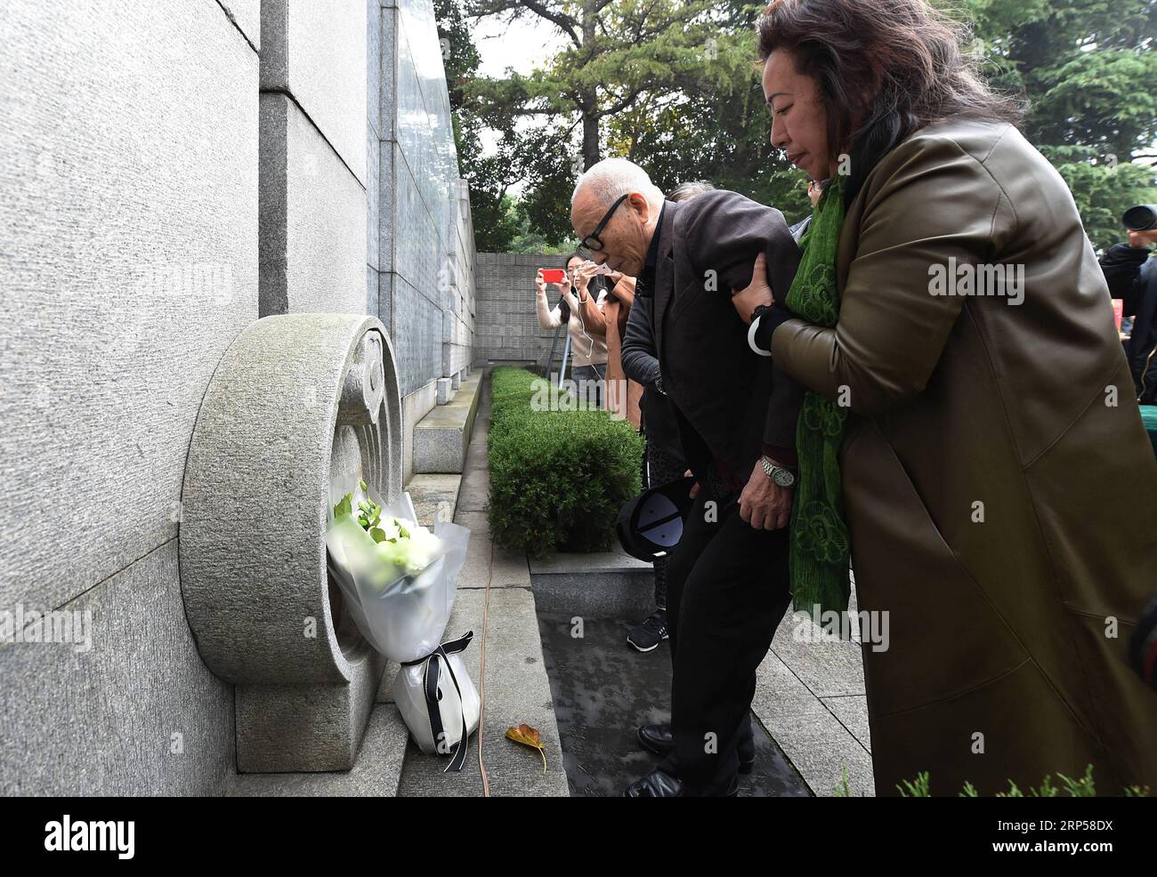(181203) -- NANJING, 3 déc. 2018 (Xinhua) -- survivant du massacre de Nankin Yu Changxiang (2e R), 91 ans, rend hommage aux victimes du massacre de Nanjing devant le mur de la salle commémorative où les noms des victimes sont gravés lors des activités commémoratives à Nanjing, capitale de la province de Jiangsu de l est de la Chine, le 3 décembre 2018. Le massacre de Nankin a eu lieu lorsque les troupes japonaises ont capturé la ville le 13 décembre 1937. En six semaines, ils ont tué 300 000 civils chinois et des soldats non armés. En février 2014, la plus haute législature de la Chine a désigné le 13 décembre comme jour commémoratif national pour les victimes de la mort Banque D'Images