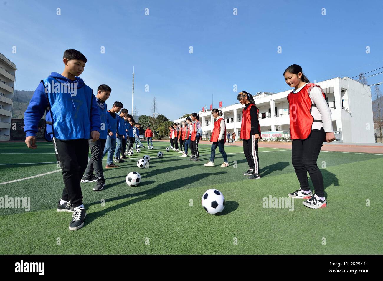 (181219) -- XIANGYANG, 19 déc. 2018 (Xinhua) -- des élèves pratiquent le soccer à l'école centrale de Xiema Town, dans le canton de Xiema, dans le comté de Baokang, dans la province du Hubei en Chine centrale, 18 déc. 2018. Xiema Town Central School, un internat rural situé dans une région montagneuse reculée de la province du Hubei, est la première école pilote de football à Baokang. L'école a construit un terrain de football en 2015, et a ajouté le football à son programme, offrant aux étudiants un accès à plus de chances de jouer au football, ainsi qu'aider les jeunes footballeurs à poursuivre leurs rêves. (Xinhua/Yang Tao) CHINA-HUBEI-RURAL-SOCC Banque D'Images