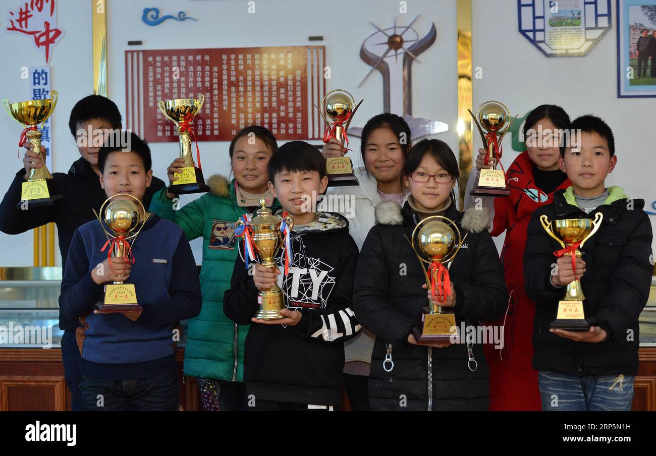 (181219) -- XIANGYANG, 19 déc. 2018 (Xinhua) -- des étudiants exposent les trophées de l'équipe de football à l'école centrale de Xiema Town, dans le canton de Xiema, dans le comté de Baokang, dans la province du Hubei, au centre de la Chine, le 18 décembre 2018. Xiema Town Central School, un internat rural situé dans une région montagneuse reculée de la province du Hubei, est la première école pilote de football à Baokang. L'école a construit un terrain de football en 2015, et a ajouté le football à son programme, offrant aux étudiants un accès à plus de chances de jouer au football, ainsi qu'aider les jeunes footballeurs à poursuivre leurs rêves. (Xinhua/Yang Tao) CHINA-HUB Banque D'Images