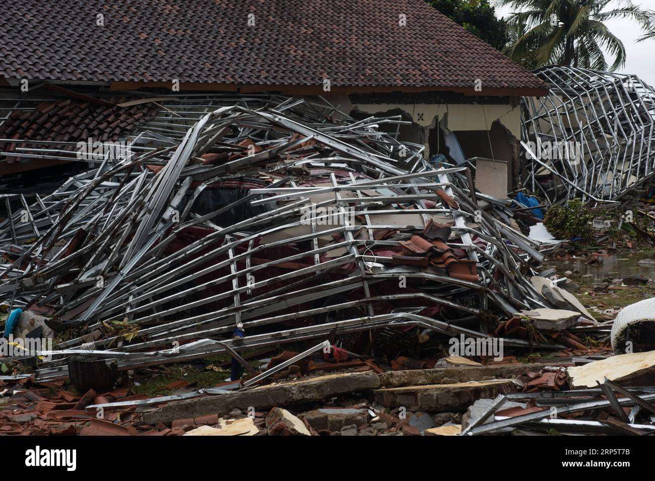 (181223) -- PANDEGLANG, 23 décembre 2018 -- Une voiture est enterrée dans des débris après qu'un tsunami ait frappé le détroit de Sunda à Pandeglang, province de Banten, en Indonésie, le 23 décembre 2018. Le nombre total de victimes d'un tsunami déclenché par l'éruption du volcan Krakatau Child a augmenté à 168 personnes dans les zones côtières du détroit de la sonde, dans l'ouest de l'Indonésie, a déclaré dimanche un responsable de l'agence de lutte contre les catastrophes. La catastrophe a tué au moins 168 personnes, en a blessé au moins 745 et a fait tomber au total 430 maisons et neuf hôtels, et causé des dommages à des dizaines de navires. INDONÉSIE-PANDEGLANG-TSUNAMI-AFTERMATH VERIXSANOVRI PUBLICATIO Banque D'Images
