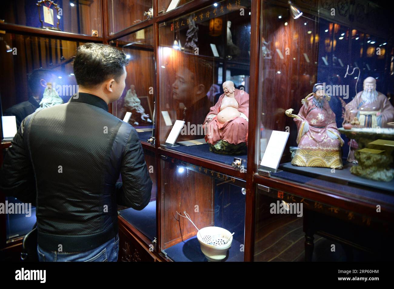 (181229) -- PÉKIN, 29 déc. 2018 (Xinhua) -- Un client regarde les figurines de la galerie d'art Clay Figure Zhang à Tianjin, dans le nord de la Chine, 28 déc. 2018. Figure d'argile Zhang est un nom familier de l'art populaire traditionnel en Chine, et une telle œuvre a une histoire de près de 200 ans. Zhang Yu, le fabricant de figurines en argile de sixième génération de sa famille, a pris en charge l’entreprise familiale en 1996, alors qu’il n’avait que 18 ans. Au fil du temps, le métier et la marque ont évolué. Au lieu de fabriquer des figurines et de les vendre comme un vendeur de rue, il a embauché des directeurs artistiques pour exploiter et commercialiser le val artistique Banque D'Images