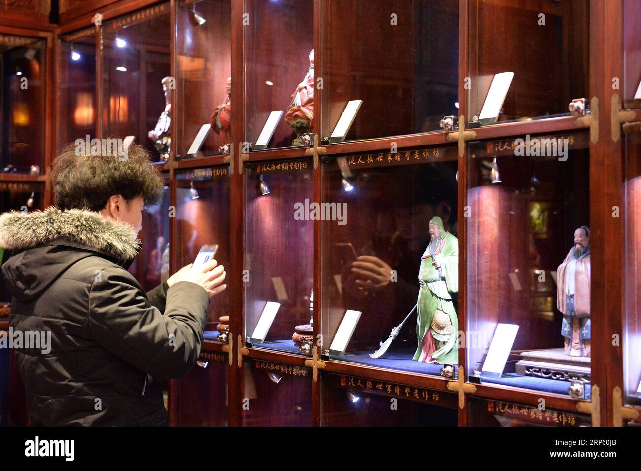 (181229) -- PÉKIN, 29 déc. 2018 (Xinhua) -- Un client regarde les figurines de la galerie d'art Clay Figure Zhang à Tianjin, dans le nord de la Chine, 28 déc. 2018. Figure d'argile Zhang est un nom familier de l'art populaire traditionnel en Chine, et une telle œuvre a une histoire de près de 200 ans. Zhang Yu, le fabricant de figurines en argile de sixième génération de sa famille, a pris en charge l’entreprise familiale en 1996, alors qu’il n’avait que 18 ans. Au fil du temps, le métier et la marque ont évolué. Au lieu de fabriquer des figurines et de les vendre comme un vendeur de rue, il a embauché des directeurs artistiques pour exploiter et commercialiser le val artistique Banque D'Images
