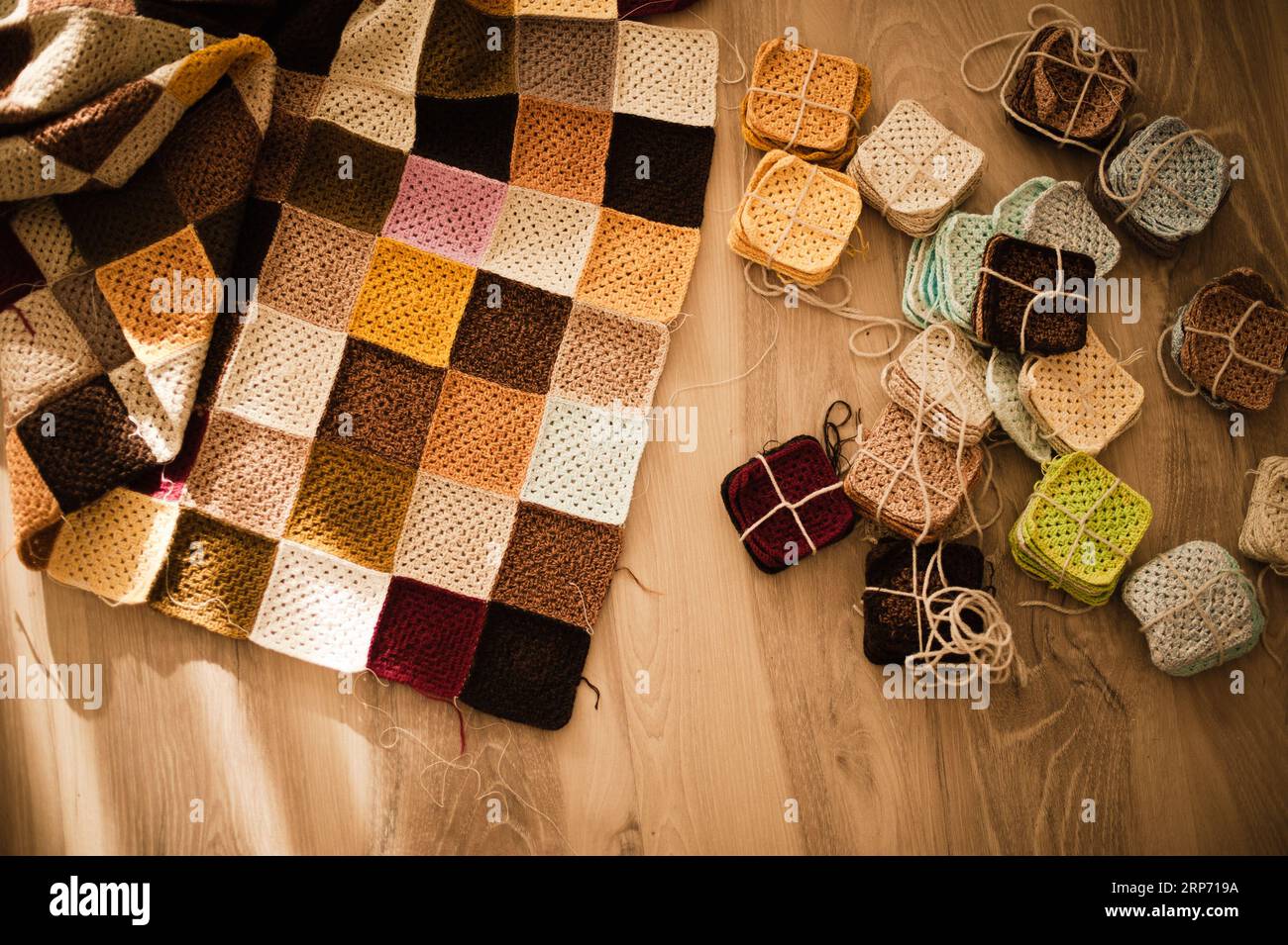 Une couverture vibrante est étalée sur un plancher en bois, accompagnée  d'une sélection d'articles crochetés faits à la main Photo Stock - Alamy