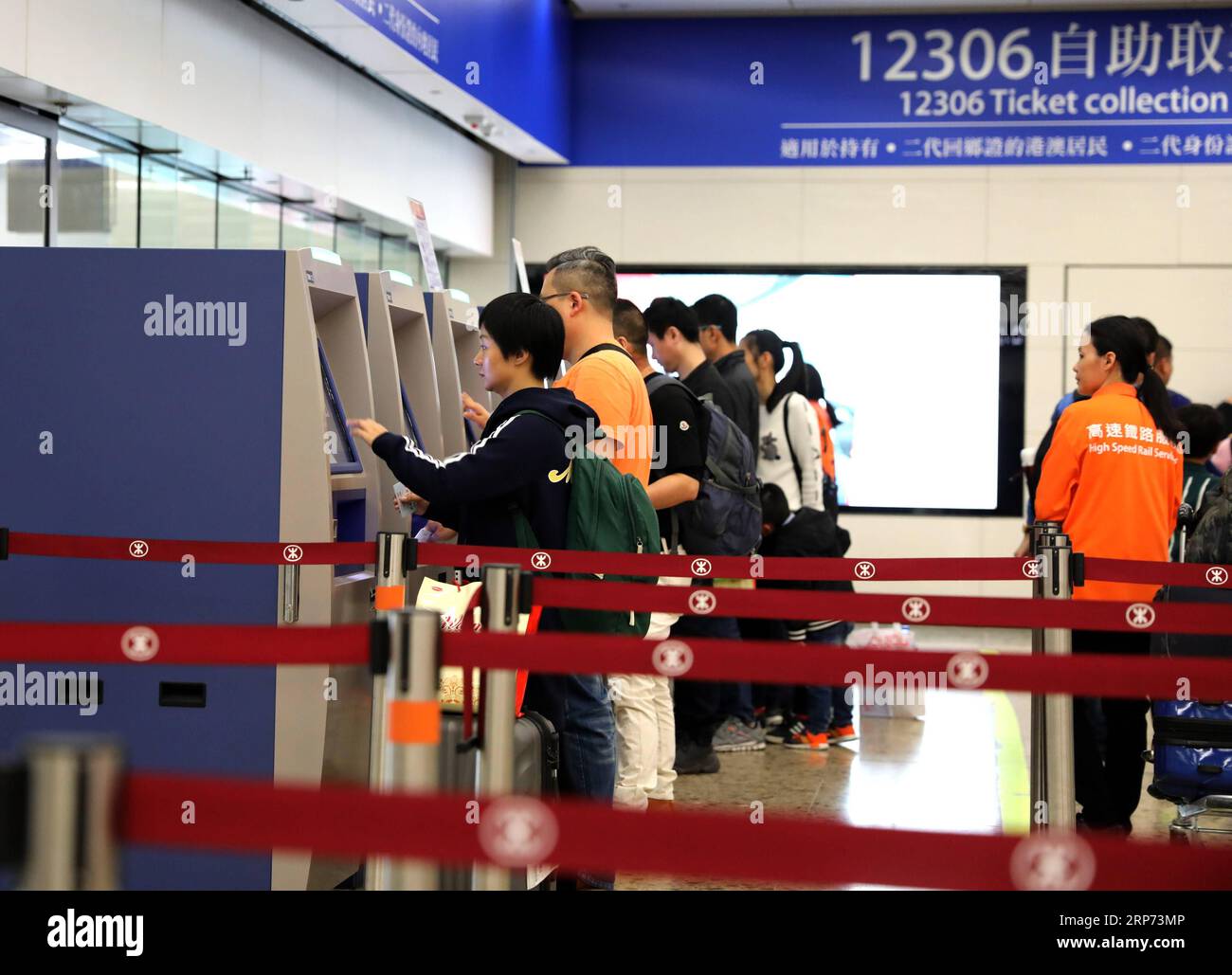 (190126) -- HONG KONG, 26 janv. 2019 (Xinhua) -- les passagers prennent leurs billets aux distributeurs automatiques de billets d'automobile à la gare de West Kowloon à Hong Kong, dans le sud de la Chine, le 25 janvier 2019. Pour mieux servir les passagers utilisant les distributeurs automatiques de billets, des panneaux bleus sont installés et des membres du personnel en orange sont envoyés pour offrir de l'aide à la gare de West Kowloon à Hong Kong. (Xinhua/Wu Xiaochu) CHINA-HONG KONG-WEST KOWLOON STATION-SERVICE (CN) PUBLICATIONxNOTxINxCHN Banque D'Images