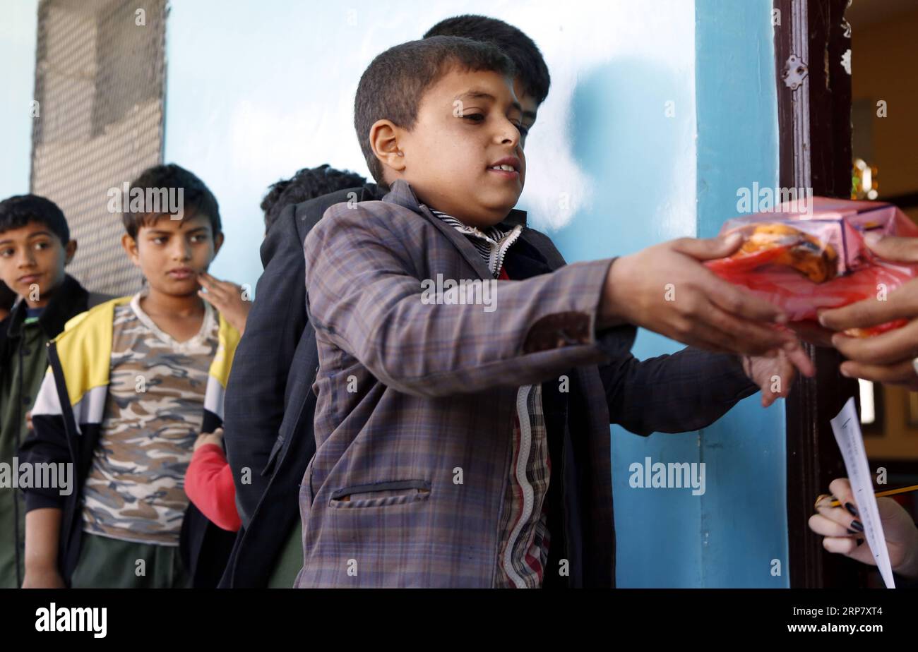 (190213) -- SANAA, 13 février 2019 -- des élèves yéménites touchés par le conflit font la queue pour recevoir un petit déjeuner assisté dans une école de Sanaa, au Yémen, le 13 février 2019. Ahmed Hameed Humran, directeur d'une école au nord de Sanaa, a déclaré que ces petits déjeuners aidés comprenant des pommes, des bananes, et des sandwichs, sont fournis par des groupes de charité locaux et des gens riches comme une tentative d'aider et d'encourager 500 élèves pauvres de l'école à aller à l'école et de ne pas être dehors.) YÉMEN-SANAA-ÉTUDIANTS-AIDE ALIMENTAIRE MohammedxMohammed PUBLICATIONxNOTxINxCHN Banque D'Images