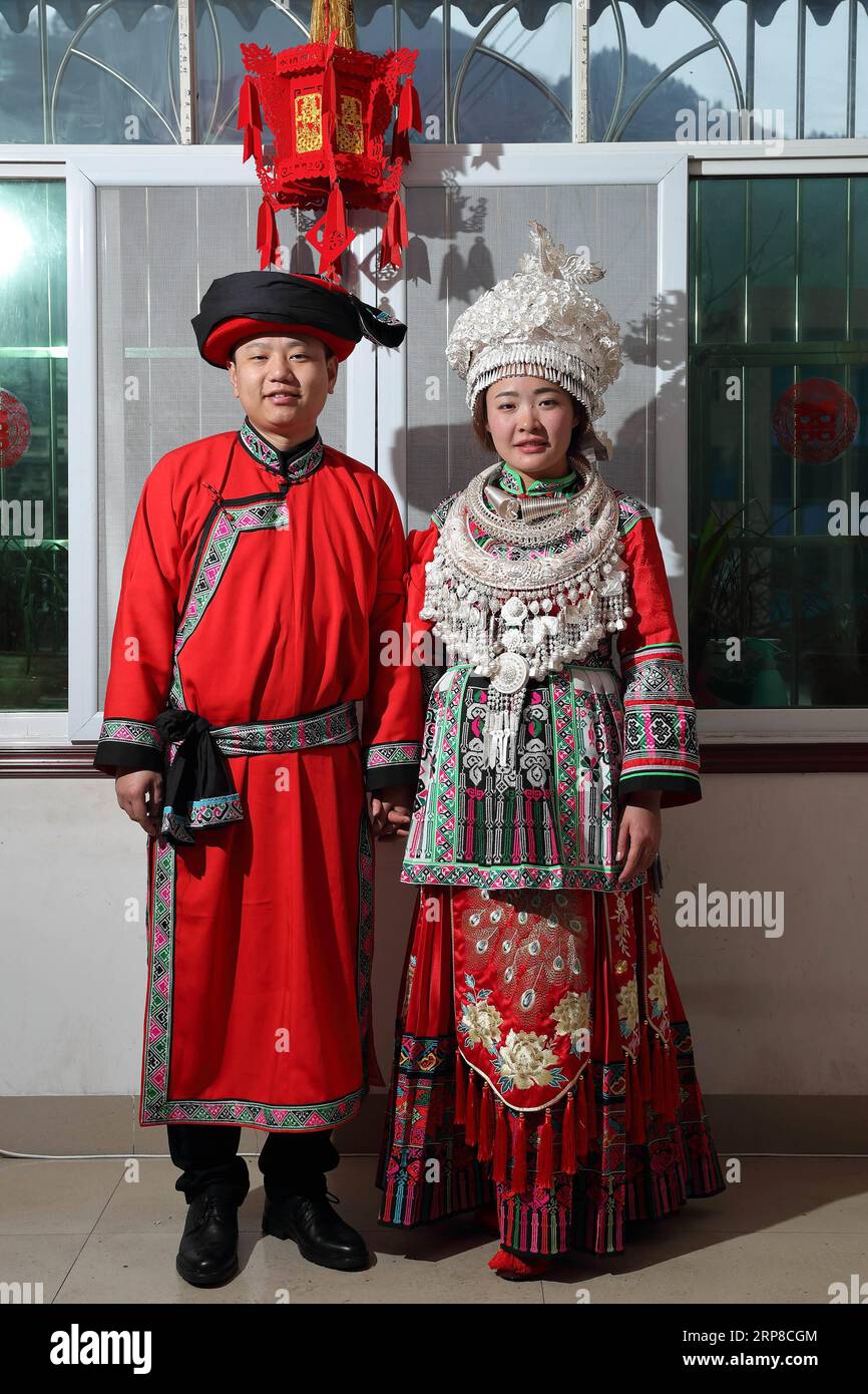 (190227) -- XINGWEN, 27 février 2019 (Xinhua) -- les jeunes mariés Yang Yuqiao (à gauche) et Han Yujie posent pour une photo dans la salle de mariage nouvellement décorée dans le comté de Xingwen, dans la province du Sichuan du sud-ouest de la Chine, le 26 février 2019. Yang Yuqiao et Han Yujie, un couple ethnique Miao, ont noué le nœud dans le style traditionnel Miao dans le comté de Wenxing, dans la province du Sichuan du sud-ouest de la Chine, du 24 au 26 février 2019. Yang Yuqiao, le marié de 25 ans, travaille comme guide touristique dans le Géoparc mondial UNESCO de Xingwen, et Han Yujie, la mariée de 23 ans, travaille comme professeur d'éducation physique dans le canton de Dahe Miao dans le comté de Xingwen. Pendant le travail bénévole de Hu Banque D'Images