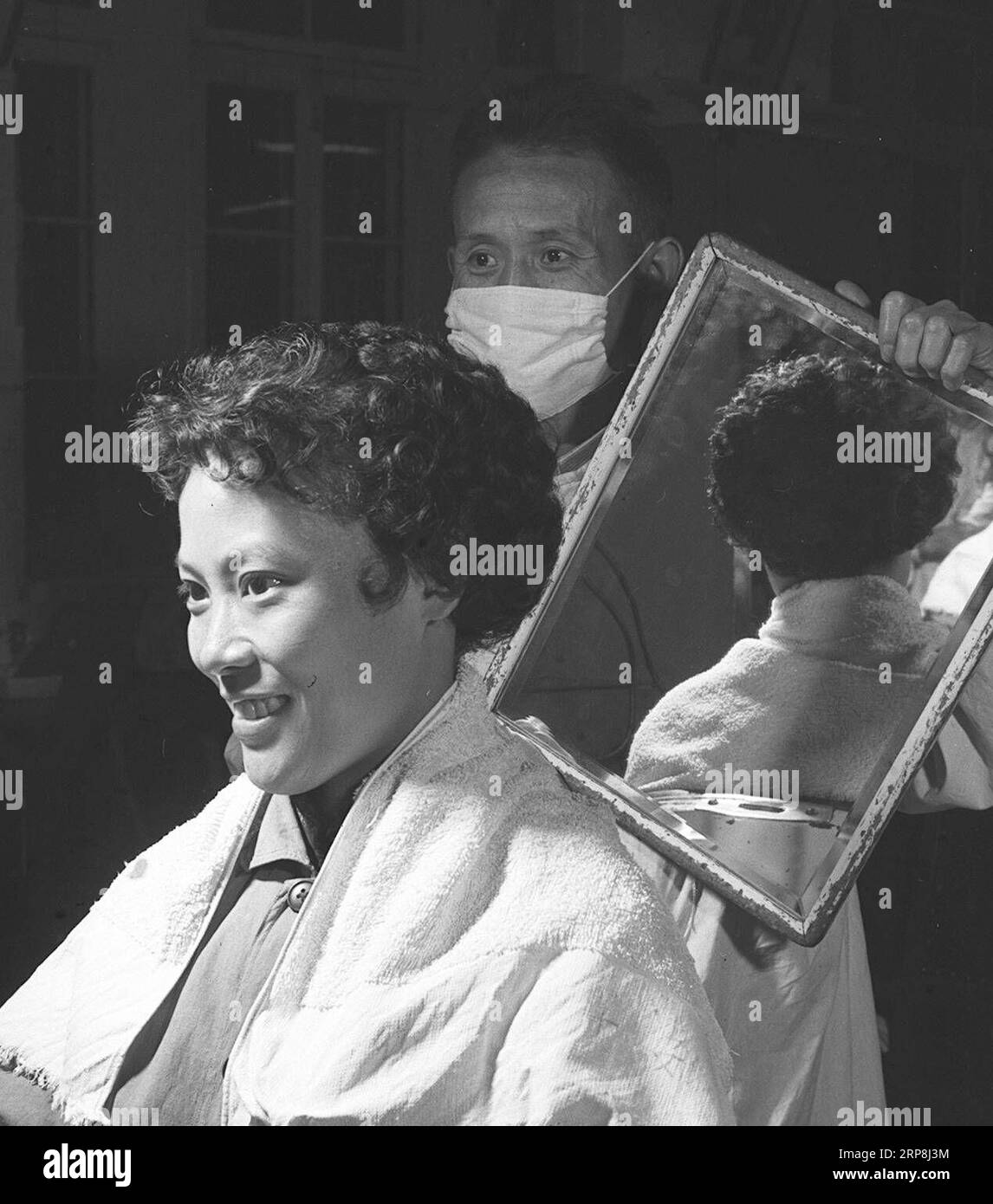 (190307) -- PÉKIN, le 7 mars 2019 -- Une femme regarde dans un miroir dans un salon de coiffure à Xidan à Pékin, capitale de la Chine, le 10 novembre 1959. Parallèlement à la réforme et à l ouverture de la Chine à partir de 1978, les femmes chinoises ont rafraîchi leurs images année après année, ce qui peut être vu simplement à partir de leurs coiffures. Les coiffures des femmes, tout comme un miroir, reflètent les changements de mode et surtout, la définition de plus en plus diversifiée de la beauté des femmes chinoises. (MOMENTS FOREVER) CHINE-FEMMES S JOUR-COIFFURES-CHANGEMENTS (CN) ANXKANG PUBLICATIONXNOTXINXCHN Banque D'Images