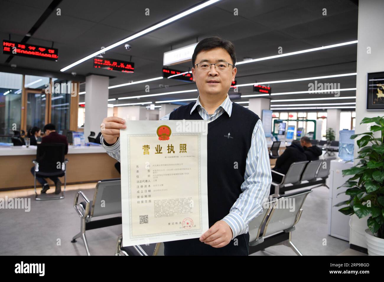 (190401) -- BEIJING, 1 avril 2019 -- Un membre du personnel d'une entreprise établie dans la nouvelle région de Xiongan montre une licence d'exploitation au centre de services aux citoyens de Xiongan dans la nouvelle région de Xiongan, province du Hebei, dans le nord de la Chine, le 17 janvier 2019.) Xinhua Headlines : la Chine va commencer la construction à grande échelle à Xiongan New Area MuxYu PUBLICATIONxNOTxINxCHN Banque D'Images