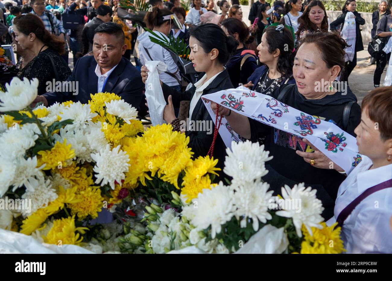 (190402) -- XICHANG, 2 avril 2019 (Xinhua) -- les gens présentent hada, un tissu de soie cérémonial pour montrer leur respect, lors d'une cérémonie de deuil spontanée pour rendre hommage à ceux qui ont perdu la vie en combattant le feu de forêt dans un salon funéraire dans la ville de Xichang, dans la province du Sichuan, au sud-ouest de la Chine, le 2 avril 2019. Un incendie qui a tué 30 personnes et englouti environ 15 hectares de forêt dans la province du Sichuan du sud-ouest de la Chine a été éteint mardi, ont déclaré les autorités locales. Trente personnes, dont 27 pompiers et trois habitants, ont perdu la vie en combattant l'incendie. (Xinhua/Zhang Chaoqun) CHINE Banque D'Images