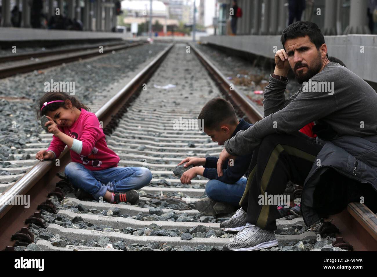 (190405) -- ATHÈNES, le 5 avril 2019 -- Un migrant et ses enfants participent à un sit-in dans une gare d'Athènes, en Grèce, le 5 avril 2019. Les frontières de la Grèce avec tout autre pays ne rouvriront pas, ont déclaré vendredi les ministres du gouvernement en réponse aux sit-in protestations organisées par des centaines de réfugiés et de migrants à Athènes et dans le nord de la Grèce. Plus de 200 migrants et réfugiés ont commencé vendredi un sit-in de protestation sur les voies ferrées de la gare centrale d'Athènes, exigeant d'être autorisés à se rendre dans le nord de la Grèce pour atteindre les frontières. Les services ferroviaires ont été suspendus jusqu'à nouvel ordre. Banque D'Images