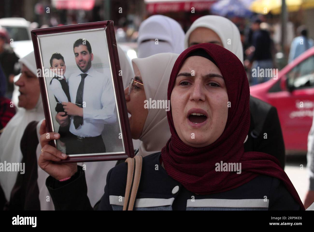 (190410) -- NAPLOUSE, 10 avril 2019 -- Une palestinienne tient une photo de son parent emprisonné en Israël lors d'une manifestation de solidarité avec les prisonniers palestiniens après qu'ils aient entamé une grève de la faim ouverte, dans la ville de Naplouse, en Cisjordanie, le 10 avril 2019. Le Club des prisonniers palestiniens a annoncé que des dizaines de prisonniers palestiniens dans les prisons israéliennes ont entamé lundi après-midi une grève de la faim ouverte. Nidal Eshtayeh) MIDEAST-NAPLOUSE-PRISONNIERS PALESTINIENS-MANIFESTATION ZhaoxYue PUBLICATIONxNOTxINxCHN Banque D'Images