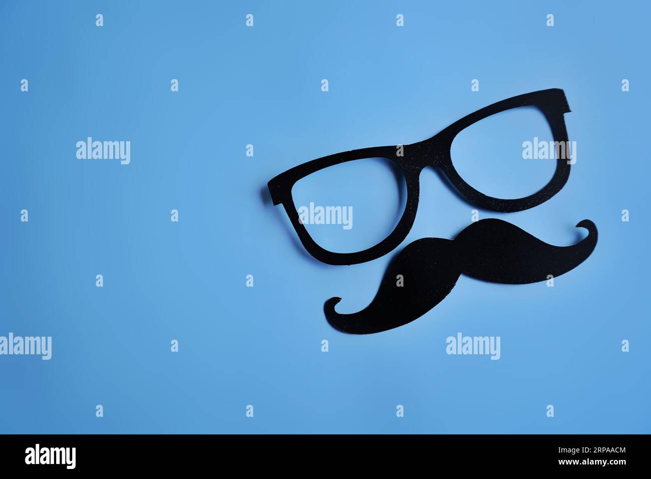 Moustache et lunettes sur fond bleu avec espace de copie. Movember, concept de santé pour hommes Banque D'Images