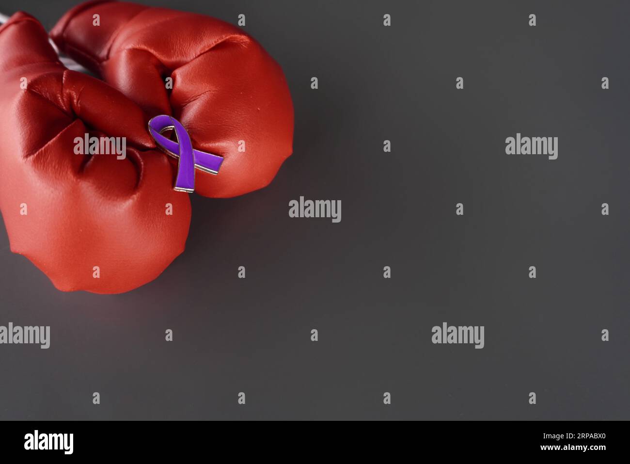 Image rapprochée de gants de boxe et ruban violet avec espace de copie. Cancer du pancréas, épilepsie et concept de sensibilisation à la maladie d'Alzheimer Banque D'Images