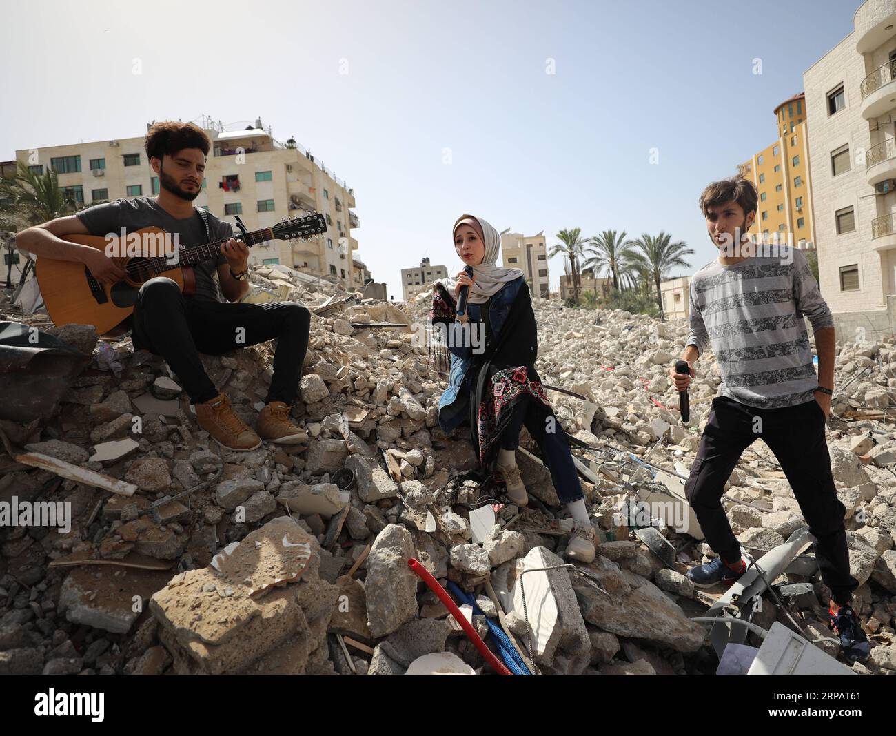 (190518) -- GAZA, 18 mai 2019 -- des artistes palestiniens se produisent sur les décombres d'un bâtiment récemment détruit par des frappes aériennes israéliennes, dans la ville de Gaza, le 18 mai 2019. Sur les ruines d’un immeuble résidentiel de la bande de Gaza détruit par des avions de guerre israéliens, un groupe de chanteurs palestiniens a envoyé samedi un message anti-israélien au Concours Eurovision de la chanson qui se tient en Israël. Yasser Qudih) MIDEAST-GAZA-MUSIC-ANTI-ISRAEL MESSAGE zhaoyue PUBLICATIONxNOTxINxCHN Banque D'Images