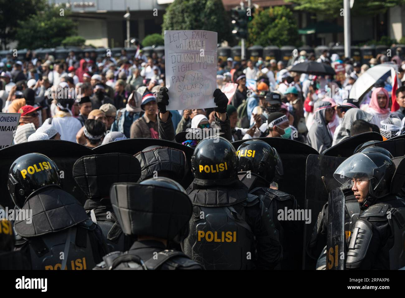 (190521) -- JAKARTA, 21 mai 2019 -- Un manifestant brandit une bannière devant le bouclier de la police lors d'un rassemblement pour rejeter le résultat de la récapitulation du vote national devant le bâtiment du Conseil de surveillance des élections à Jakarta, Indonésie, le 21 mai 2019. Joko Widodo a remporté sa réélection avec 55,5 pour cent des voix, défaisant son rival ardent, l'ancien général de l'armée Prabowo Subianto qui a obtenu 44,5 pour cent des voix, a annoncé mardi la Commission électorale générale indonésienne (KPU). INDONÉSIE-JAKARTA-ÉLECTION PRÉSIDENTIELLE-RASSEMBLEMENT VerixSanovri PUBLICATIONxNOTxINxCHN Banque D'Images