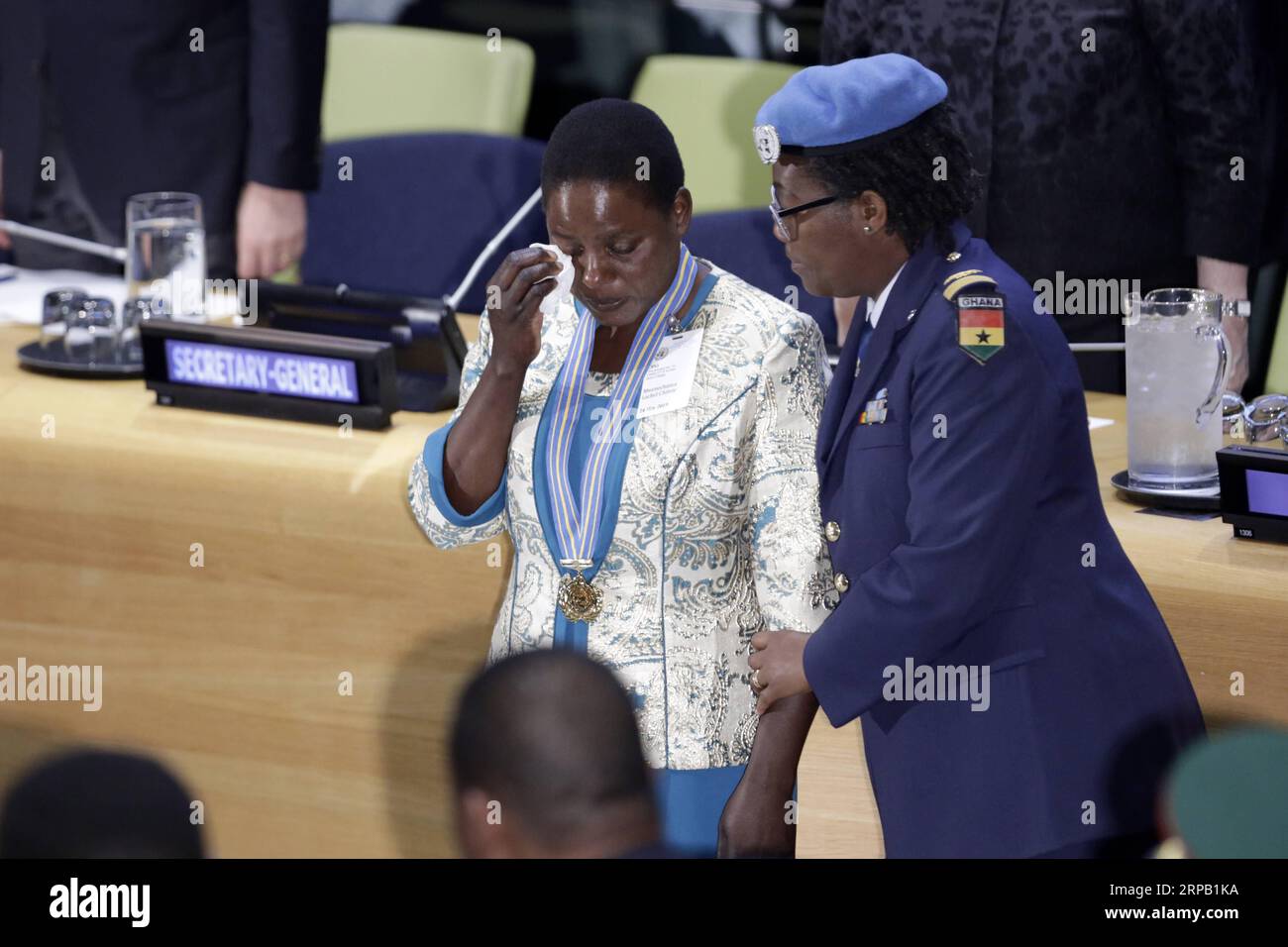 (190524) -- NATIONS UNIES, 24 mai 2019 -- Chitete Mwenechanya (G), qui porte autour du cou la médaille décernée à son défunt mari, essuie ses larmes lors d'une cérémonie au siège de l'ONU à New York, le 24 mai 2019. Un soldat malawien, qui a donné sa vie pour sauver un camarade d'armes dans une opération de l'ONU en République démocratique du Congo (RDC) en novembre 2018, a reçu vendredi, à titre posthume, la plus haute et la plus prestigieuse reconnaissance pour le maintien de la paix de l'ONU. La médaille Capitaine Mbaye Diagne pour courage exceptionnel a été décernée au soldat Chancy Chitete. Sa famille a reçu la médaille en son nom f Banque D'Images