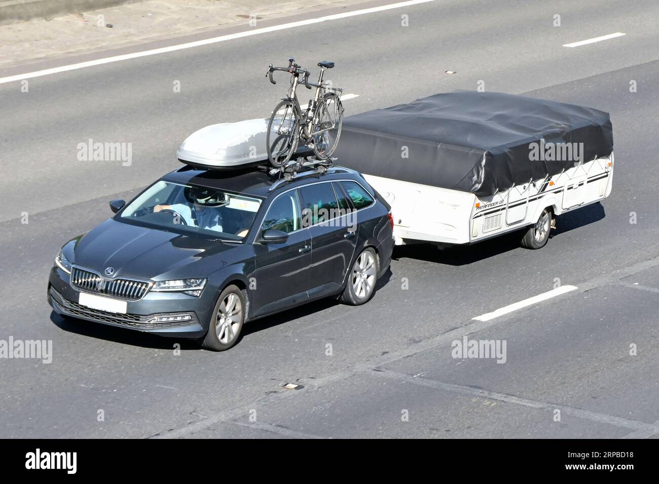 Remorque de camping pliante à hayon noire à cinq portes équipée d'un coffre à bagages de toit de couverture et porte-vélos conduisant la route d'autoroute M25 Angleterre Royaume-Uni Banque D'Images