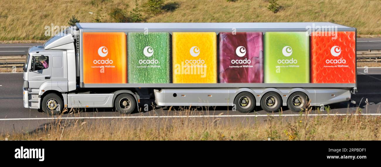 Vue latérale Ocado unité d'alimentation poids lourd conducteur de camion et livraison multicolore graphiques de remorque articulée conduisant le long de la route d'autoroute m25 Angleterre Royaume-Uni Banque D'Images