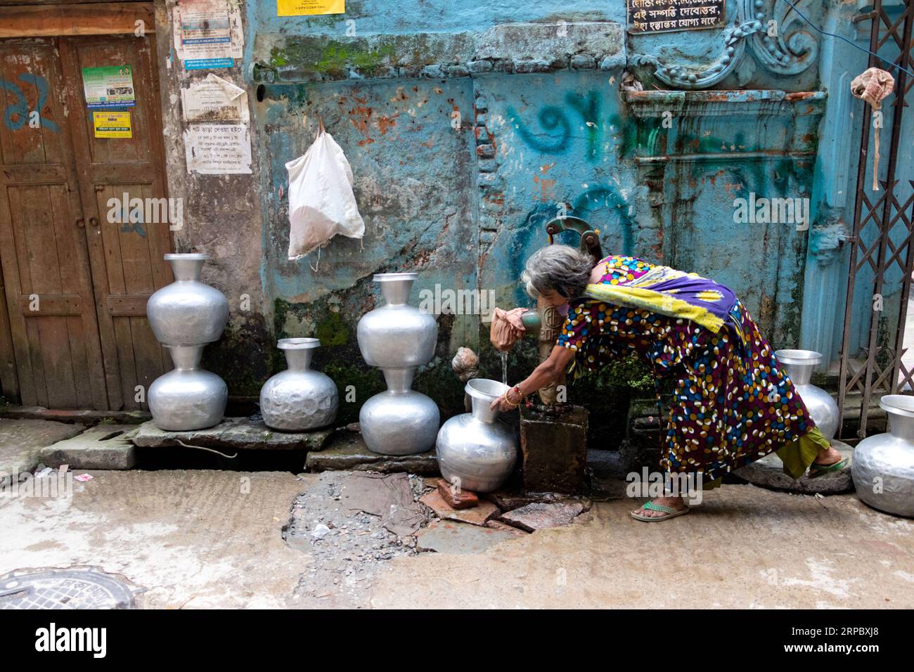 Dhaka, Dhaka, Bangladesh. 4 septembre 2023. Une femme va chercher de l’eau potable dans un puits tubulaire profond dans une rue de Dhaka, au Bangladesh. L'eau potable est une crise régulière dans les centres-villes de la ville. Environ 80% des demandes totales en eau de la ville de Dhaka sont satisfaites par l'extraction des eaux souterraines avec des niveaux d'eau souterraine qui s'appauvrissent à un rythme de 2-3 mètres par an, épuisant rapidement cette ressource. Crédit : ZUMA Press, Inc./Alamy Live News Banque D'Images