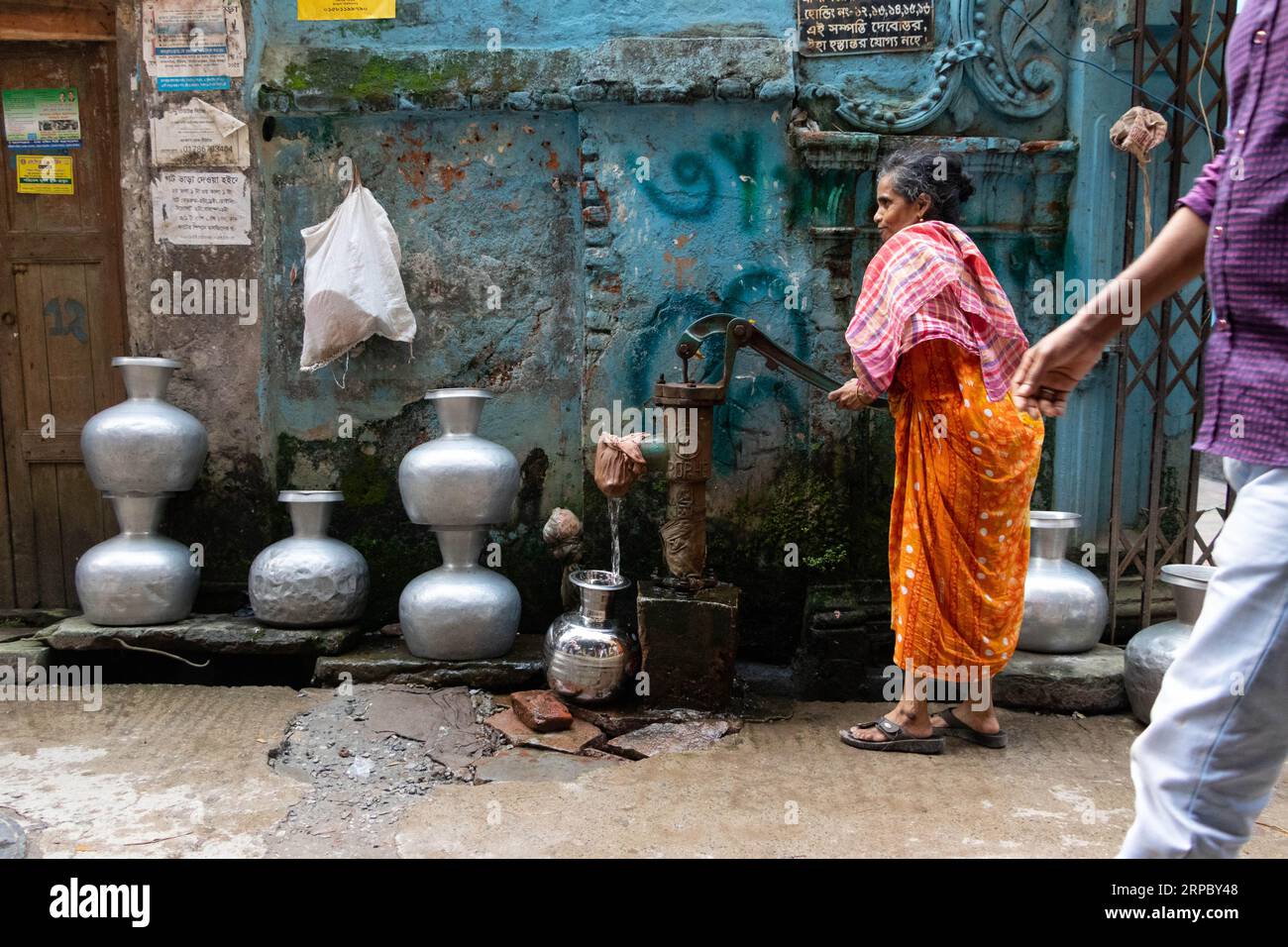 Dhaka, Dhaka, Bangladesh. 4 septembre 2023. Une femme va chercher de l’eau potable dans un puits tubulaire profond dans une rue de Dhaka, au Bangladesh. L'eau potable est une crise régulière dans les centres-villes de la ville. Environ 80% des demandes totales en eau de la ville de Dhaka sont satisfaites par l'extraction des eaux souterraines avec des niveaux d'eau souterraine qui s'appauvrissent à un rythme de 2-3 mètres par an, épuisant rapidement cette ressource. Crédit : ZUMA Press, Inc./Alamy Live News Banque D'Images