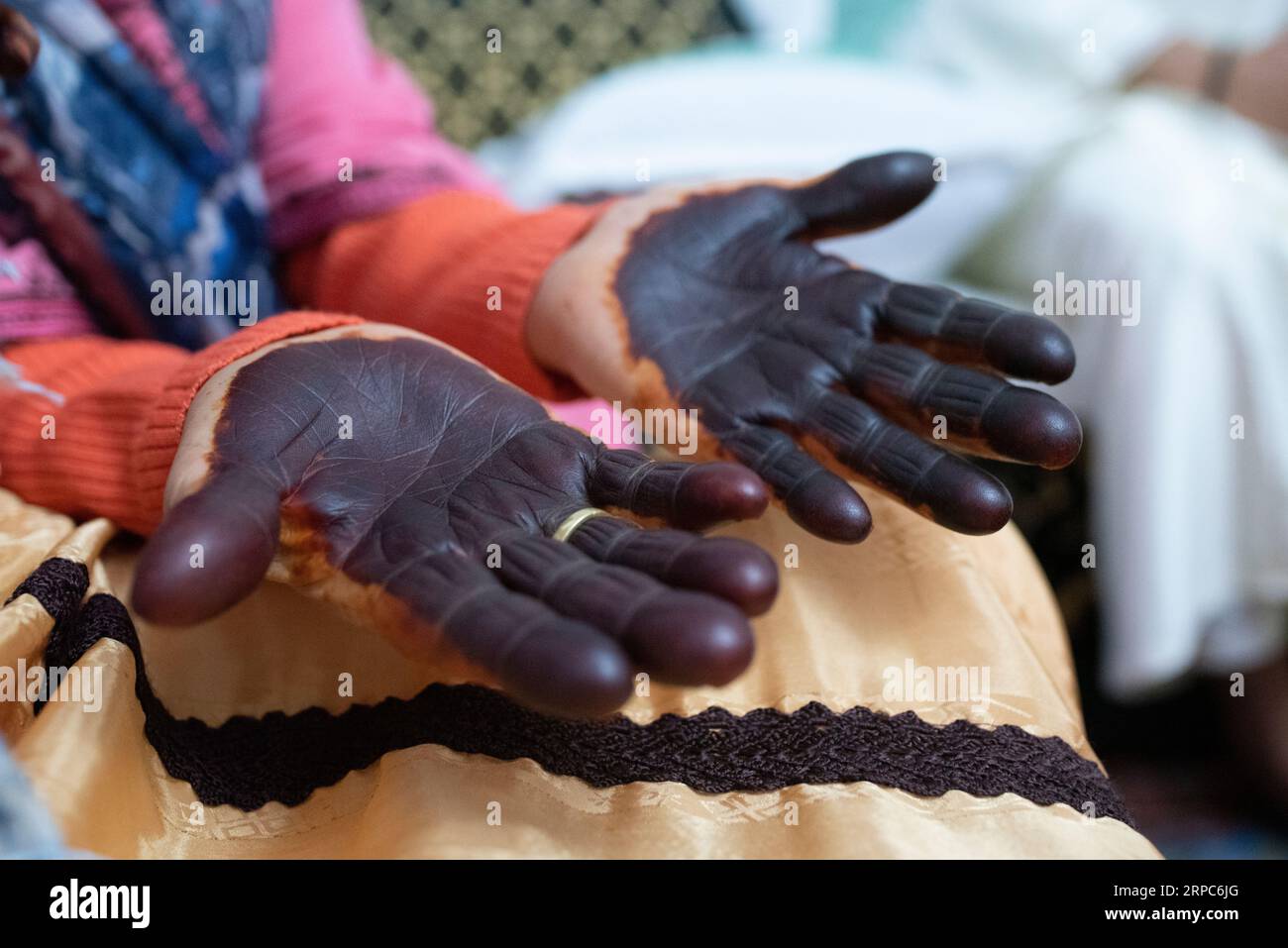 Gros plan d'une femme âgée peinte les mains avec du henné en célébration. Banque D'Images