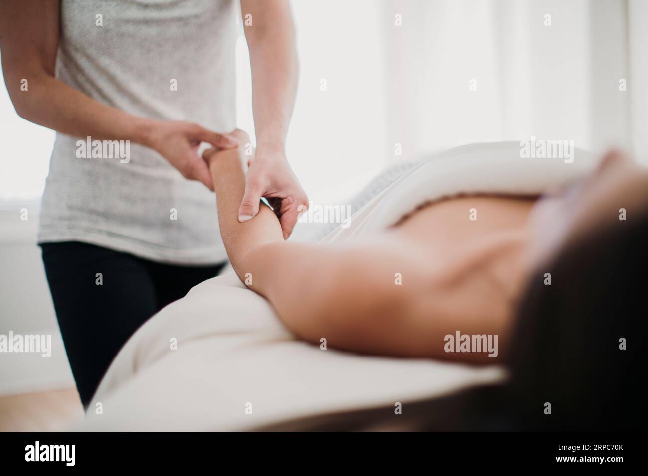 Une femme reçoit un massage d'un thérapeute dans un environnement relaxant Banque D'Images