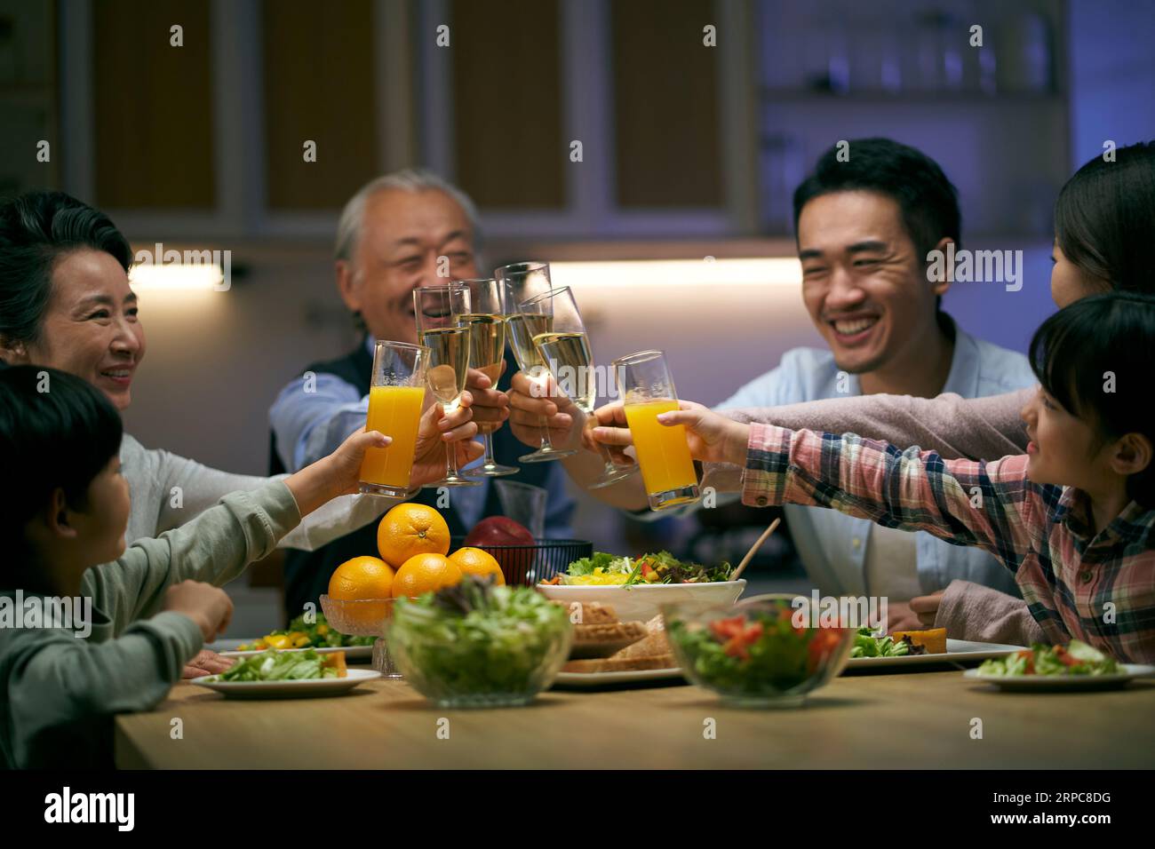 réunion de famille asiatique de trois générations à la maison célébrant les vacances en portant un toast Banque D'Images