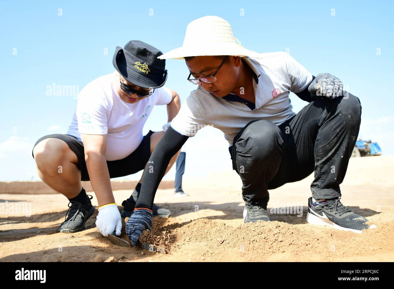 (190706) -- XI AN, 6 juillet 2019 -- Xu Puzhe (à droite), archéologue, enseigne à un passionné d'archéologie à utiliser une pelle à main sur les restes d'une ancienne ville de la dynastie Zhou orientale (770-256 av. J.-C.) dans le village de Liujiawa du comté de Chengcheng, province du Shaanxi, au nord-ouest de la Chine, le 5 juillet 2019. Plus de 30 passionnés d'archéologie ont visité la base archéologique de Weinan et le site archéologique de Liujiawa de la dynastie Zhou orientale vendredi. Sous la direction des archéologues, ils ont appris à utiliser des outils tels que la pelle Luoyang et la pelle à main, expérimentant le travail archéologique de près. CHINE- Banque D'Images