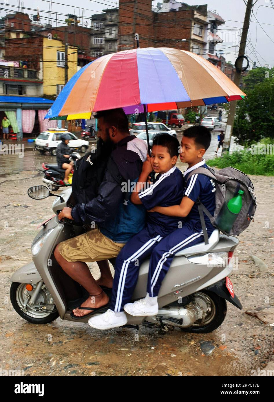 (190712) -- KATMANDOU, le 12 juillet 2019 -- un homme emmène ses enfants à l'école pendant les pluies à Katmandou, Népal, le 12 juillet 2019. Le Népal a été frappé par de fortes pluies depuis jeudi soir. ) NÉPAL-KATMANDOU-MOUSSON-PLUIE sunilxsharma PUBLICATIONxNOTxINxCHN Banque D'Images