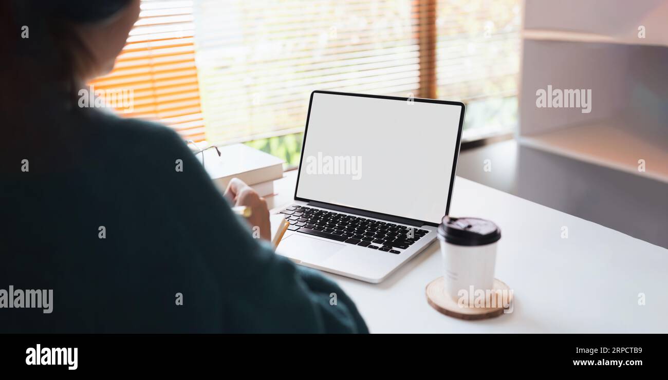 Jeune femme d'affaires d'Asie utiliser un ordinateur portable avec l'affichage blanc de maquette d'écran blanc blanc blanc pour le texte de publicité tout en travaillant à son lieu de travail Banque D'Images