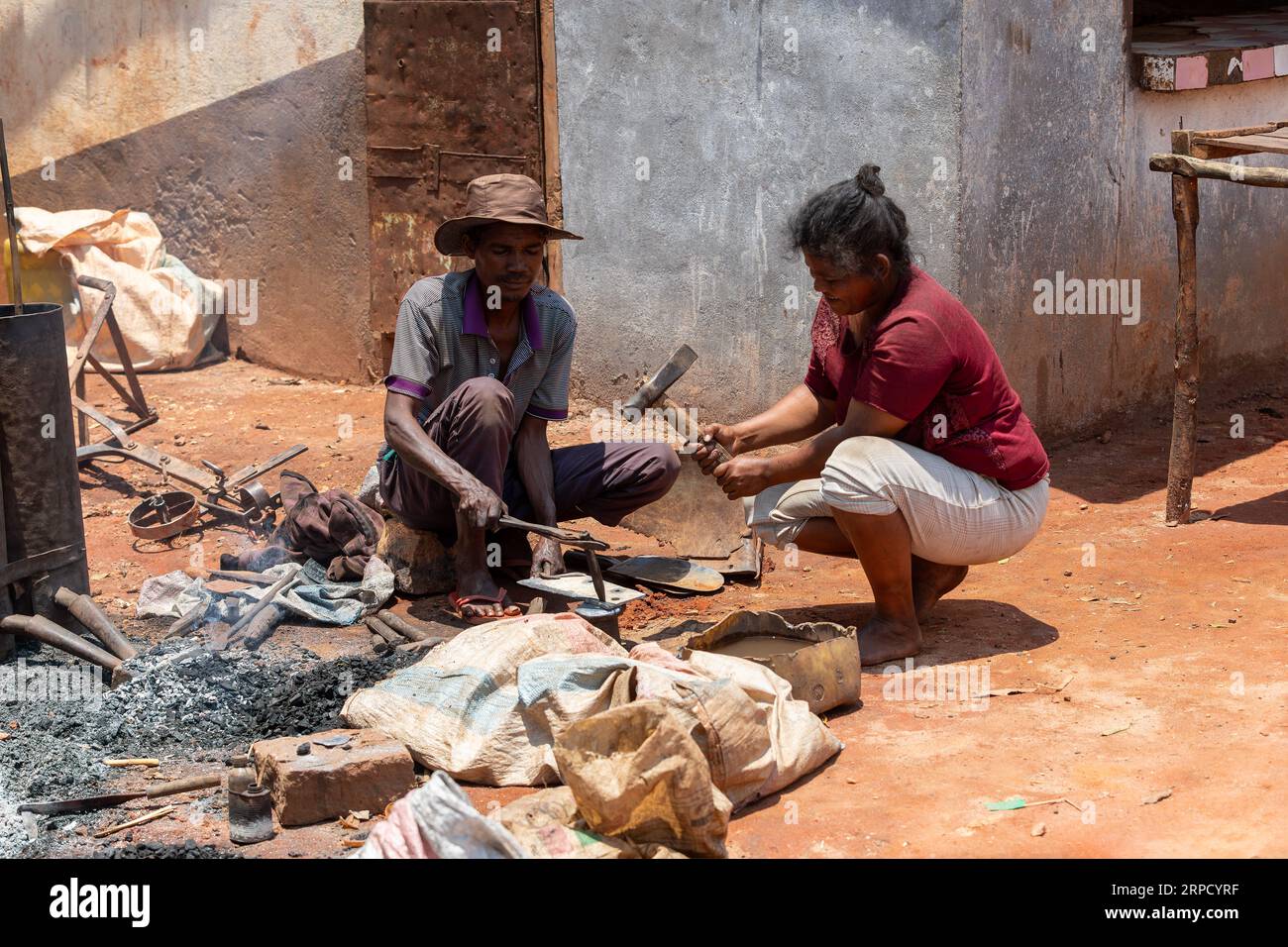 Mandoto, Madagascar - 9 novembre 2022 - Un couple malgache dirige une entreprise de forge à Mandoto. Un forgeron malgache travaille sur le fer tandis que son wi Banque D'Images