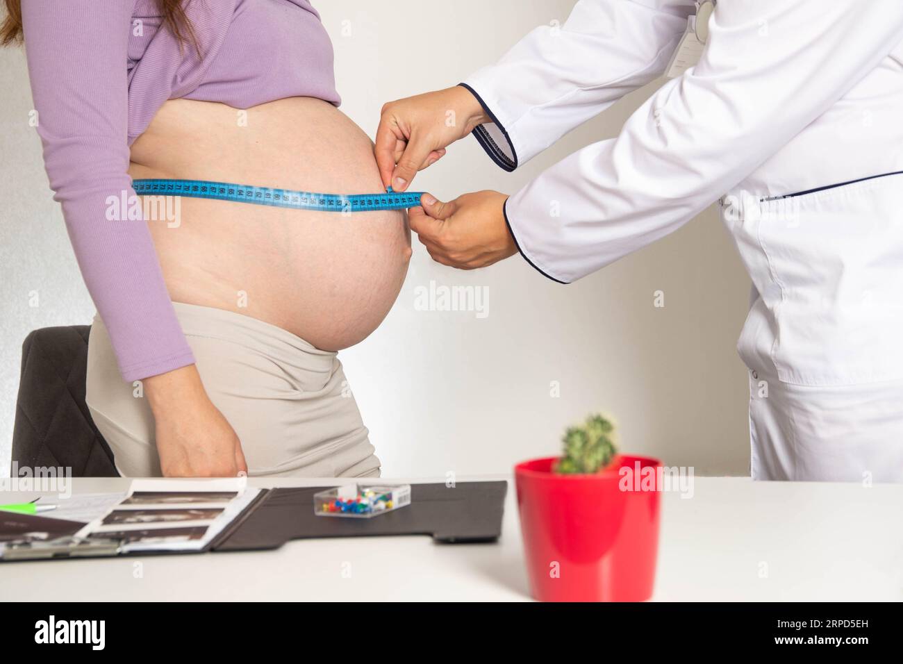 Le médecin mesure le ventre d'une femme enceinte avec un ruban à mesurer. Le concept du développement de la grossesse, la définition du volume de Banque D'Images