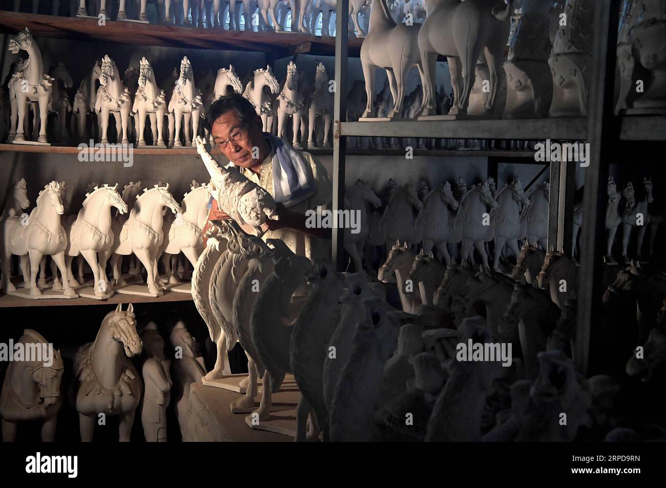 (190727) -- ZHENGZHOU, 27 juillet 2019 -- Gao Shuiwang, héritier de la technique de poterie vitrée tricolore, vérifie une poterie non émaillée dans un entrepôt dans le village de Nanshishan du comté de Mengjin dans la ville de Luoyang, province du Henan en Chine centrale, 23 juillet 2019. Sancai, ou poterie vitrée tricolore, est faite d'argile blanche et recouverte d'une couche de glaçure. La technique de production de Sancai, qui prévalait sous la dynastie Tang (618-907 AD), était très complexe et figurait parmi les héritages nationaux immatériels de la Chine en 2008. Gao Shuiwang, un maître artisan de 61 ans, s’est consacré au cours des quatre dernières années Banque D'Images