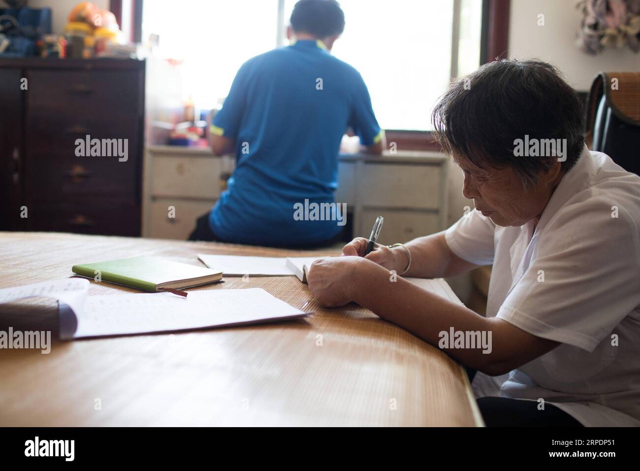 (190809) -- NANCHANG, 9 août 2019 -- Gao Yinshui étudie avec son petit-fils Chen Hailin dans le village de Lixin de la ville de Meiling dans le district de Wanli de la ville de Nanchang, province de Jiangxi dans l'est de la Chine, 8 août 2019. Presque tous les jours au cours des quatre dernières décennies, Gao Yinshui, médecin de village de 69 ans, marche sur des kilomètres sur des routes de montagne pour voir ses patients dans neuf villages différents. Fin 1970, la mère de Gao a eu une urgence et a eu la chance d être sauvée par un médecin rural local. À cause de cela, Gao Yinshui a renoncé à l'opportunité d'être enseignant et a choisi de devenir médecin rural. Cependant, elle n'a pas de médecine Banque D'Images