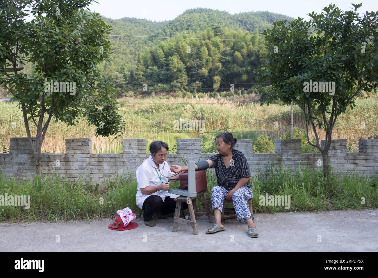 (190809) -- NANCHANG, 9 août 2019 -- Gao Yinshui vérifie la pression sanguine d'un villageois dans le village de Lixin de la ville de Meiling dans le district de Wanli de la ville de Nanchang, province de Jiangxi dans l'est de la Chine, 8 août 2019. Presque tous les jours au cours des quatre dernières décennies, Gao Yinshui, médecin de village de 69 ans, marche sur des kilomètres sur des routes de montagne pour voir ses patients dans neuf villages différents. Fin 1970, la mère de Gao a eu une urgence et a eu la chance d être sauvée par un médecin rural local. À cause de cela, Gao Yinshui a renoncé à l'opportunité d'être enseignant et a choisi de devenir médecin rural. Cependant, elle n'a pas de fou médical Banque D'Images