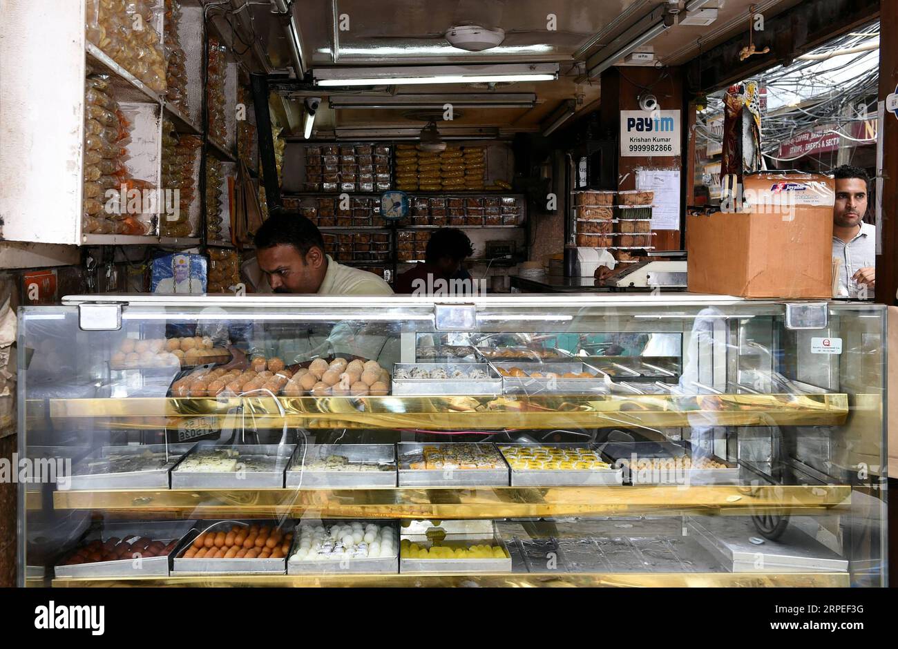 (190827) -- NEW DELHI, 27 août 2019 -- Un vendeur vend des ladoos dans un magasin de desserts traditionnels à New Delhi, Inde, le 27 août 2019. Ladoo est un bonbon indien généralement fait de farine, de sucre, d'huile végétale, d'épices et de noix. Il y a beaucoup de magasins de desserts vendant des ladoos à travers New Delhi. Les Ladoos sont aimés par les habitants, soit comme collation de thé pour les pauses de l'après-midi, soit comme plat lors de banquets festifs.) INDE-NOUVEAU DELHI-DESSERT-LADOO ZhangxNaijie PUBLICATIONxNOTxINxCHN Banque D'Images