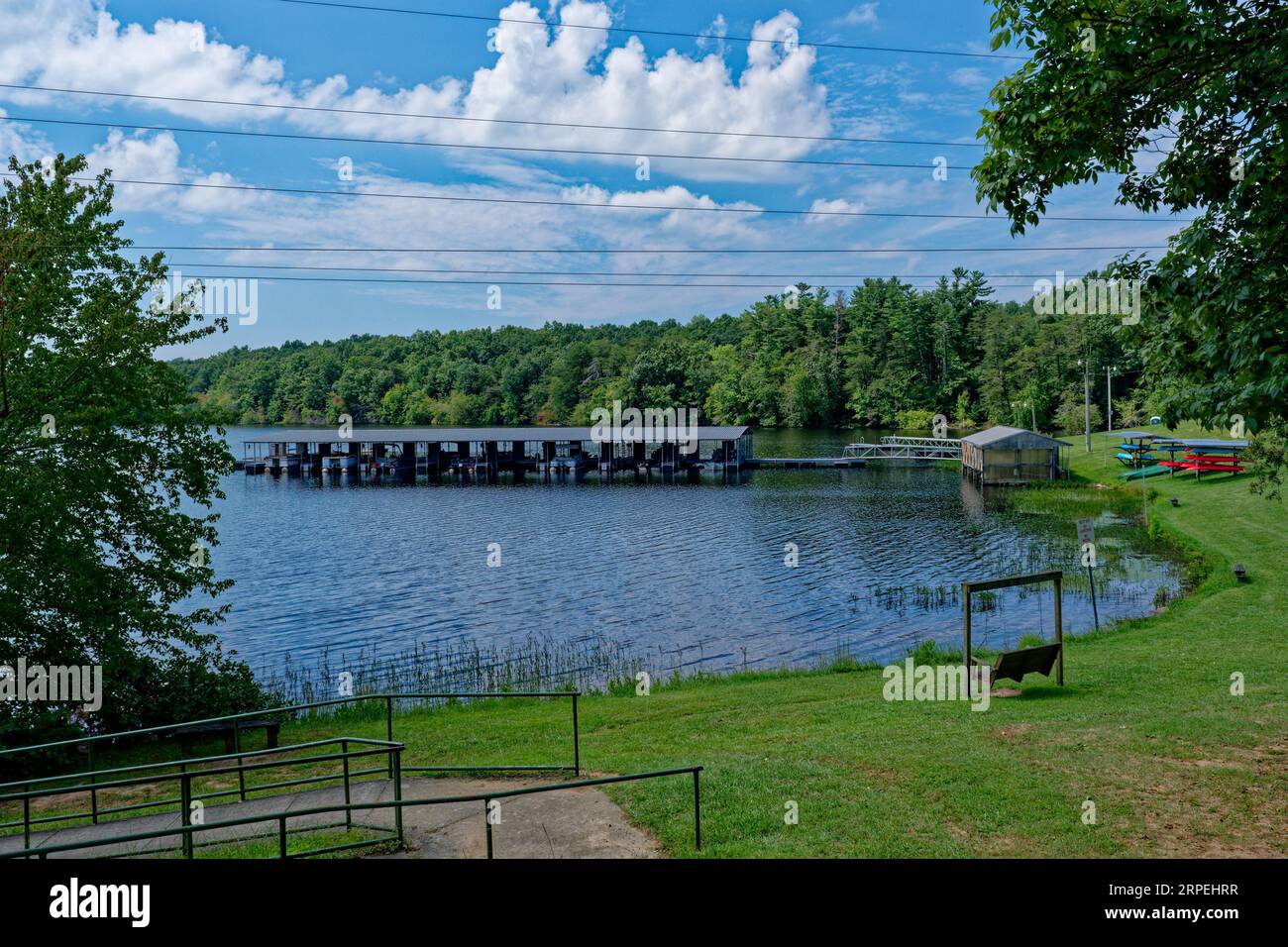 Une marina et un parc avec pontons bateaux canoës et kayaks et bancs pour s'asseoir au bord de l'eau sur une journée ensoleillée en été dans le Tennessee Banque D'Images Une marina et un parc avec pontons bateaux canoës et kayaks et bancs pour s'asseoir au bord de l'eau sur une journée ensoleillée en été dans le Tennessee Banque D'Images