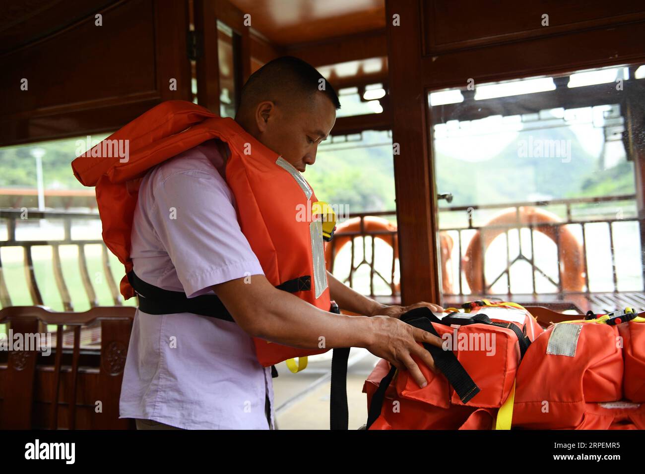 (190901) -- LINGYUN, 1 septembre 2019 -- Lao Ketuan arrange des gilets de sauvetage avant de conduire son bateau touristique sur le site pittoresque du lac Haokun dans le comté de Lingyun, dans la région autonome de Guangxi Zhuang du sud de la Chine, 30 août 2019. Lao Ketuan, 40 ans, vit dans le village montagneux de Haokun, un endroit où les transports sont extrêmement médiocres et où les ressources foncières sont rares, ce qui a sérieusement entravé le développement local et a plongé les gens dans la pauvreté. La famille AJO fait partie des ménages pauvres qui vivent ici. En 2016, Lao n’avait cependant jamais rêvé que sa famille puisse sortir de la pauvreté grâce à l’autho local Banque D'Images