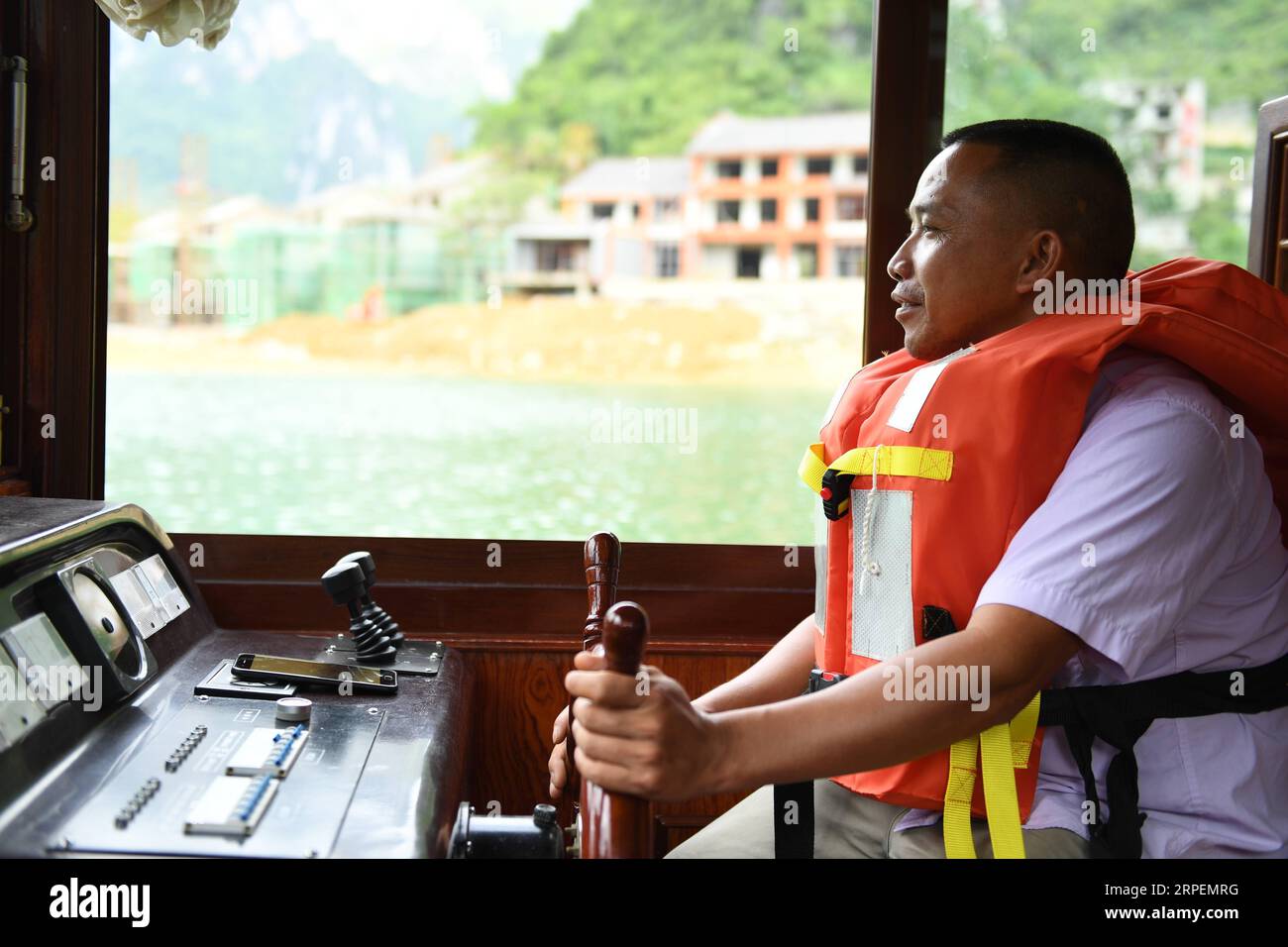 (190901) -- LINGYUN, 1 septembre 2019 -- Lao Ketuan conduit son bateau touristique au point pittoresque du lac Haokun dans le comté de Lingyun, dans la région autonome de Guangxi Zhuang, dans le sud de la Chine, 30 août 2019. Lao Ketuan, 40 ans, vit dans le village montagneux de Haokun, un endroit où les transports sont extrêmement médiocres et où les ressources foncières sont rares, ce qui a sérieusement entravé le développement local et a plongé les gens dans la pauvreté. La famille AJO fait partie des ménages pauvres qui vivent ici. En 2016, Lao n’avait cependant jamais rêvé que sa famille puisse sortir de la pauvreté grâce au travail des autorités locales sur la pauvreté allev Banque D'Images