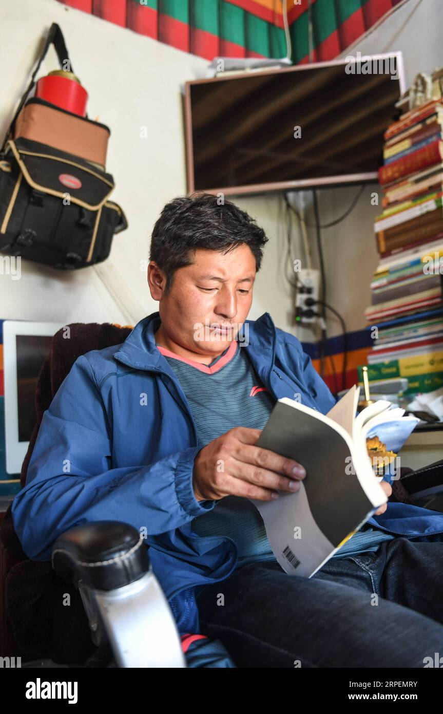 (190901) -- NGARI, 1 septembre 2019 (Xinhua) -- Basang Cering lit un livre après avoir travaillé dans le comté de Zanda de la préfecture de Ngari, dans la région autonome du Tibet du sud-ouest de la Chine, le 30 juillet 2019. Chaque année, environ 100 000 000 personnes visitent les ruines d'un mystérieux royaume antique dans l'ouest du Tibet. La plupart sont des touristes qui traversent brièvement, mais pas Basang Cering. L'homme de 30 ans entretient les reliques du Royaume de Guge depuis 2013 dans le comté de Zanda, préfecture de Ngari, région autonome du Tibet du sud-ouest de la Chine. Il a étudié une technique traditionnelle de peinture tibétaine appelée thangka à l'Université du Tibet, et est devenu Banque D'Images