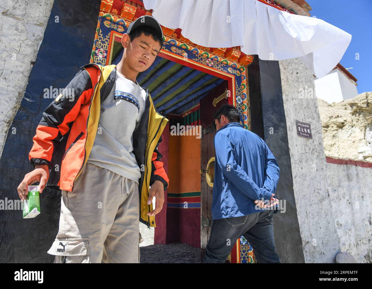 (190901) -- NGARI, 1 septembre 2019 (Xinhua) -- Basang Cering (à droite) passe par l'entrée des reliques du Royaume de Guge dans le comté de Zanda de la préfecture de Ngari, région autonome du Tibet au sud-ouest de la Chine, 30 juillet 2019. Chaque année, environ 100 000 000 personnes visitent les ruines d'un mystérieux royaume antique dans l'ouest du Tibet. La plupart sont des touristes qui traversent brièvement, mais pas Basang Cering. L'homme de 30 ans entretient les reliques du Royaume de Guge depuis 2013 dans le comté de Zanda, préfecture de Ngari, région autonome du Tibet du sud-ouest de la Chine. Il a étudié une technique traditionnelle de peinture tibétaine appelée thangka Banque D'Images