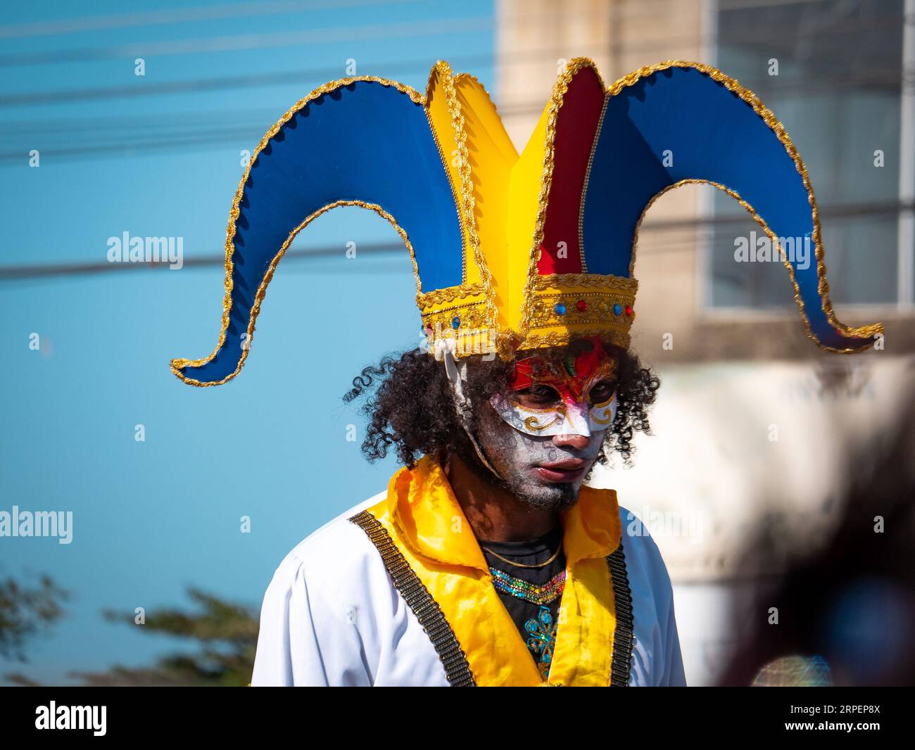 Barranquilla, Atlantico, Colombie - février 18 2023 : Homme colombien avec des défilés de maquillage portant un chapeau Arlequin bleu, rouge et jaune Banque D'Images