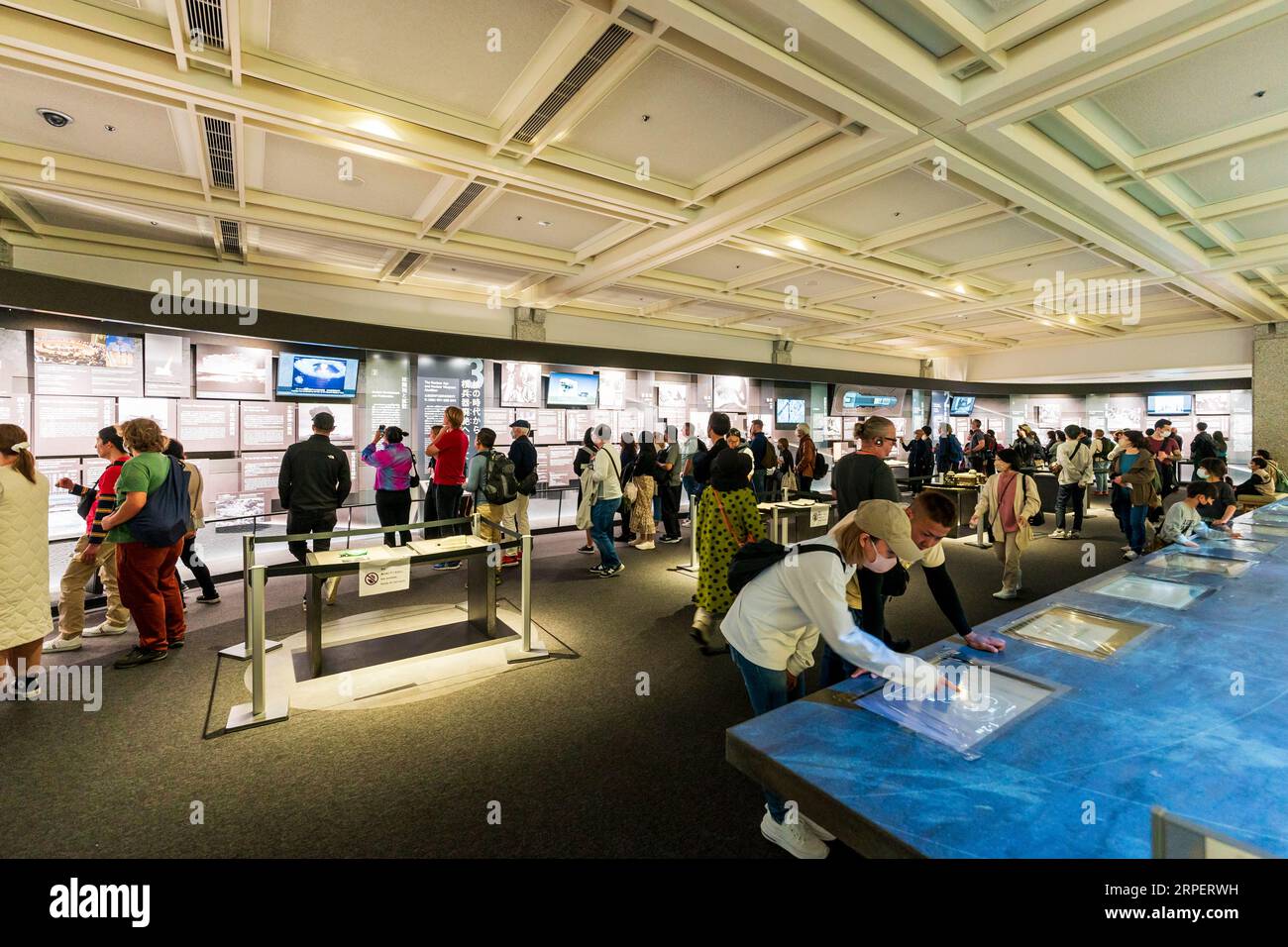 Vue intérieure, les gens regardent des expositions dans la salle de la table des médias dédiée aux dangers de la guerre nucléaire dans le musée de la paix d'Hiroshima. Banque D'Images