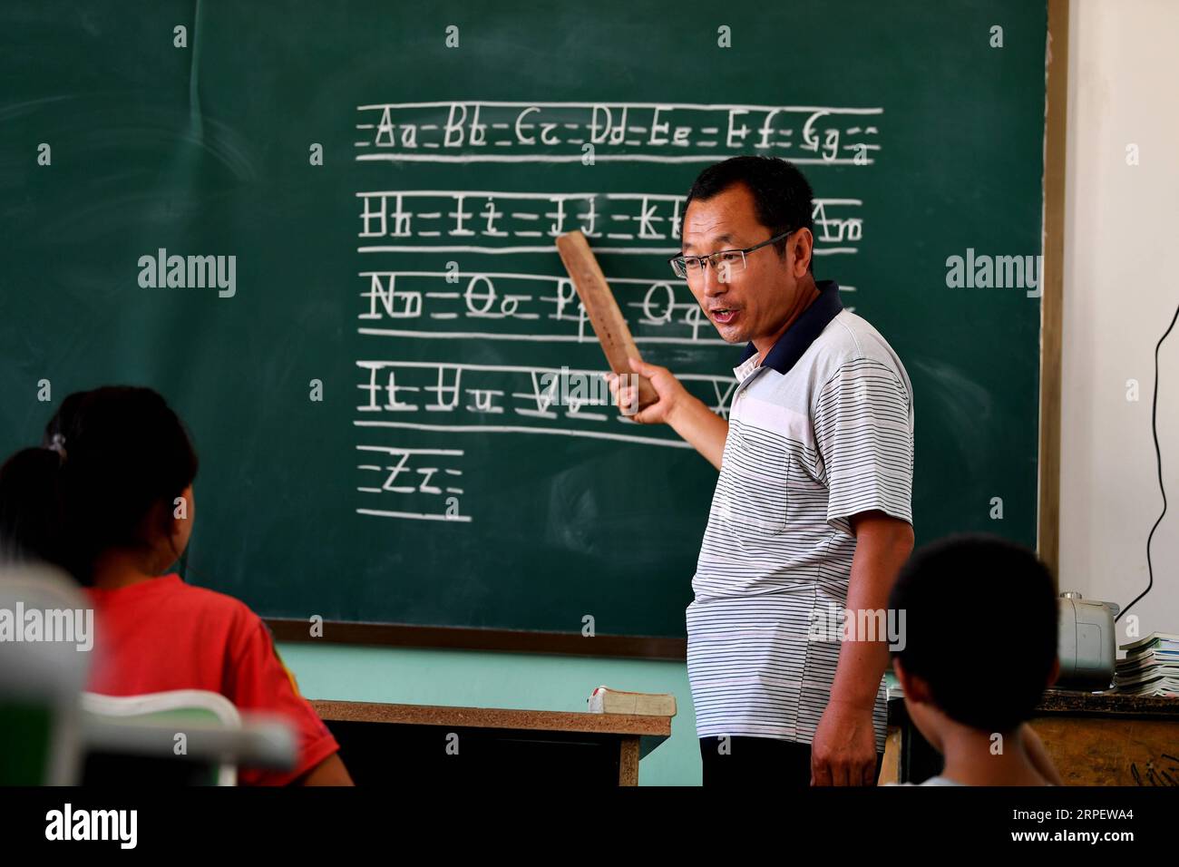 (190905) -- LIULIN, 5 septembre 2019 -- l'enseignant rural Wang Fuping donne un cours d'anglais à l'école primaire de Yangjiawa dans le village de Yangjiawa, dans le canton de Gaojiagou, dans le comté de Liulin, Lyuliang, province du Shanxi du nord de la Chine, 2 septembre 2019. Situé dans les profondes montagnes Lyuliang de la province du Shanxi, le village de Yangjiawa est presque isolé du monde extérieur, où les villageois doivent passer plus d'une heure à courir sur des routes de montagne accidentées pour se rendre au siège du comté. L’école primaire de Yangjiawa est la seule école pour les enfants du village. Wang Fuping, 39 ans, travaille comme enseignant rural depuis 19 ans Banque D'Images