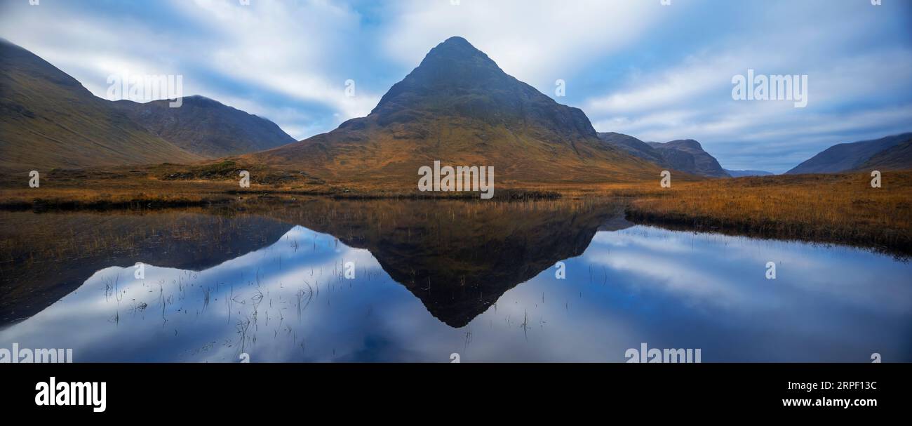 Image panoramique cousue de Buachaille etive beag et nuages spectaculaires reflétés dans Lochan na fola, Glencoe, Lochaber, Highlands, Écosse Royaume-Uni en automne Banque D'Images