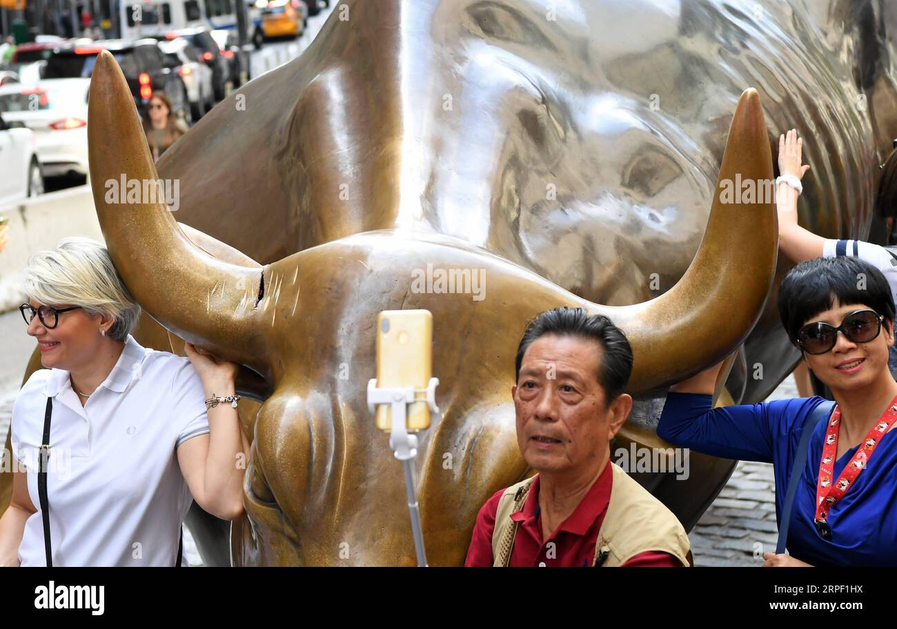 (190909) -- NEW YORK, 9 septembre 2019 -- des touristes posent pour des photos près du Wall Street Charging Bull endommagé à New York, aux États-Unis, le 9 septembre 2019. Un homme a été arrêté le 7 septembre pour avoir endommagé la statue emblématique de Wall Street Charging Bull à New York avec un objet ressemblant à un banjo, ont rapporté les médias locaux. U.S.-NEW YORK-CHARGEMENT BULL-DAMAGE LIXRUI PUBLICATIONXNOTXINXCHN Banque D'Images